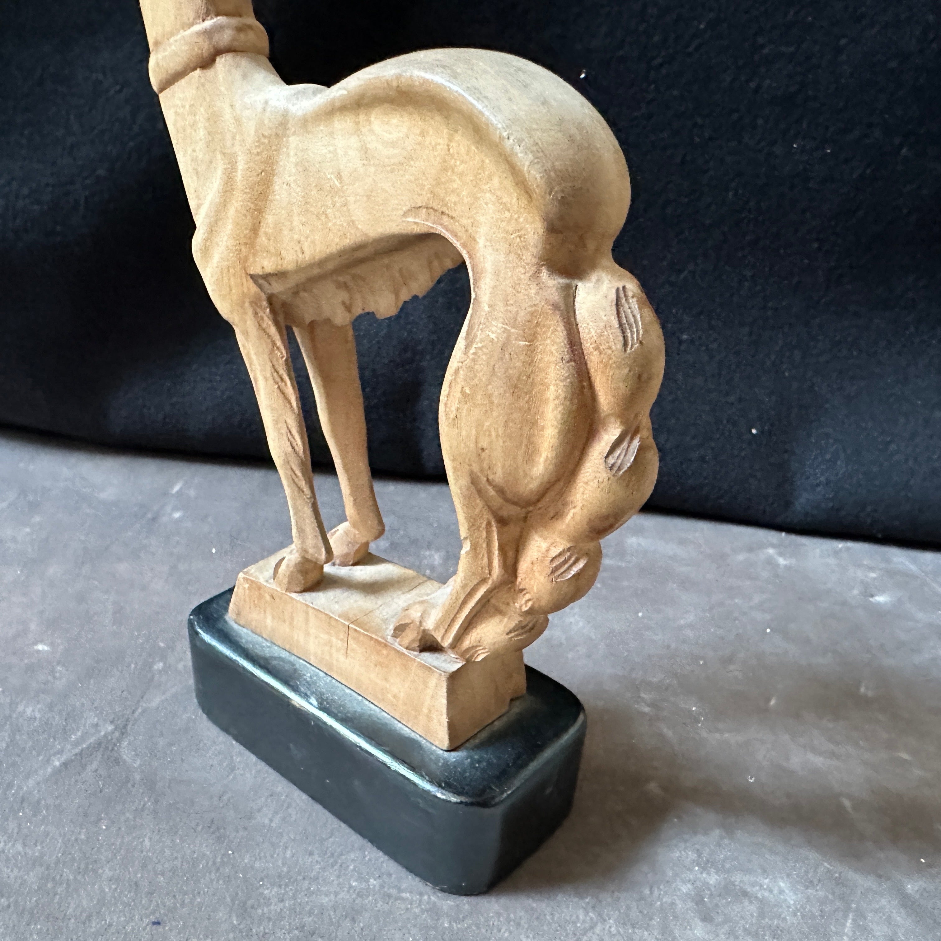 Cette figurine Art déco des années 1930 représentant un lévrier, sculptée à la main, est un exemple typique de l'élégance épurée et des formes stylisées associées au mouvement Art déco. La figure sculptée dans du bois aux tons clairs avec une