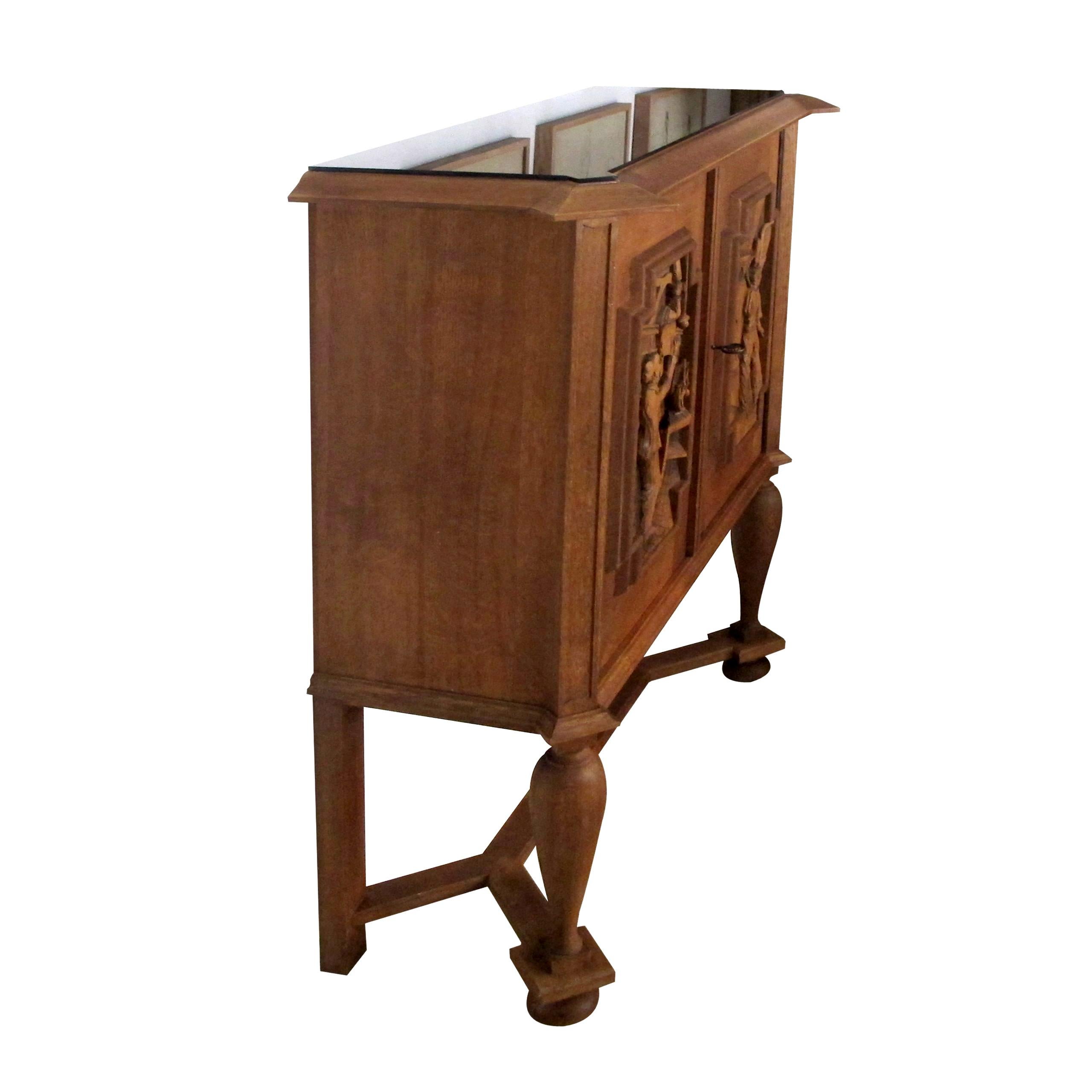A signed and dated 1946 oak cabinet with beautifully carved doors by E. Hallanvaara with a black glass top and adjustable shelving. The cabinet was gifted to a paper mill worker, Ing. Hans Honauer for his 50th birthday by his colleague workers. The