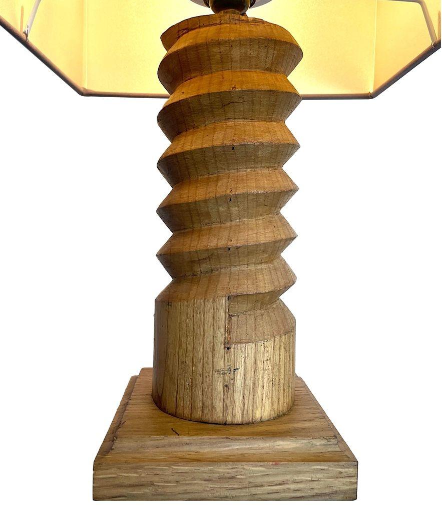 A 1940s French hand carved oak table lamp in the style of Charles Dudouyt with spiral cork screw design. Re wired with new brass fitting, antique gold cord flex and new mushroom coloured bespoke shade with champagne lining. 
    