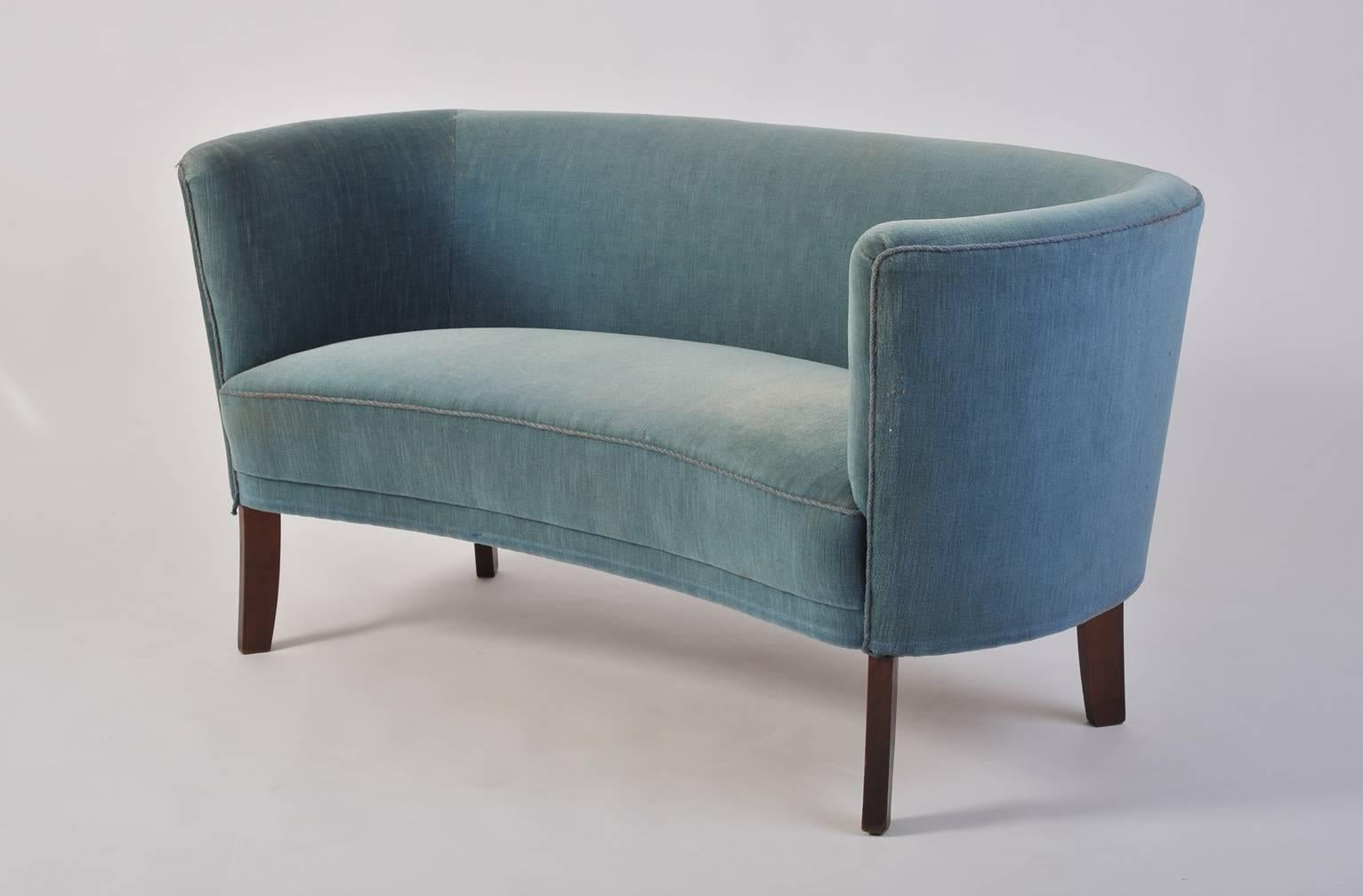 A curved 'loveseat' sofa, in its original blue velvet upholstery
Sweden, circa 1940.