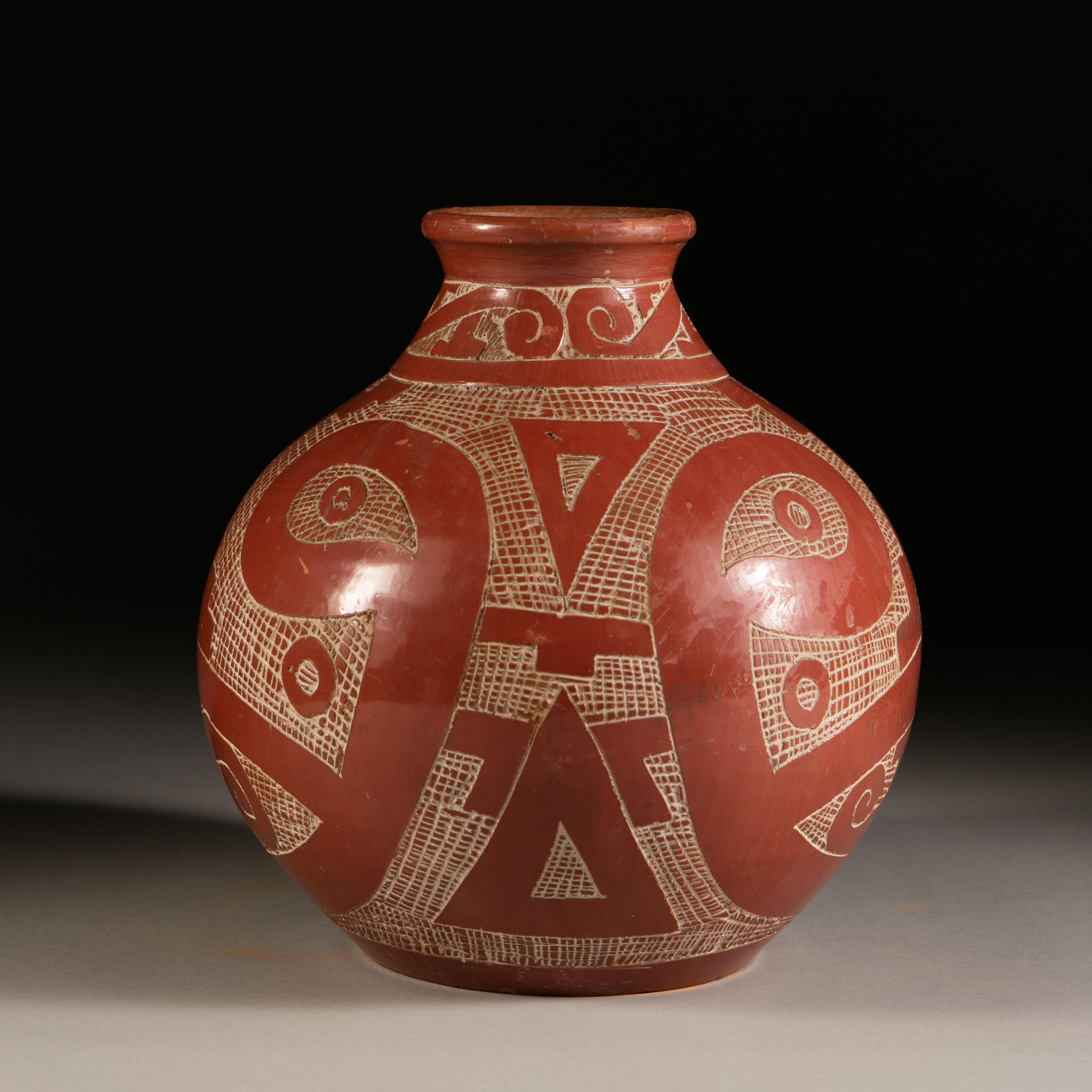 A mid-20th century terracotta vessel, with burnt umber glaze and incised with interlocking C-scrolls in the South American taste. Signed to the underside.

Please note: Lampshade not included.

Currently wired for the UK.
