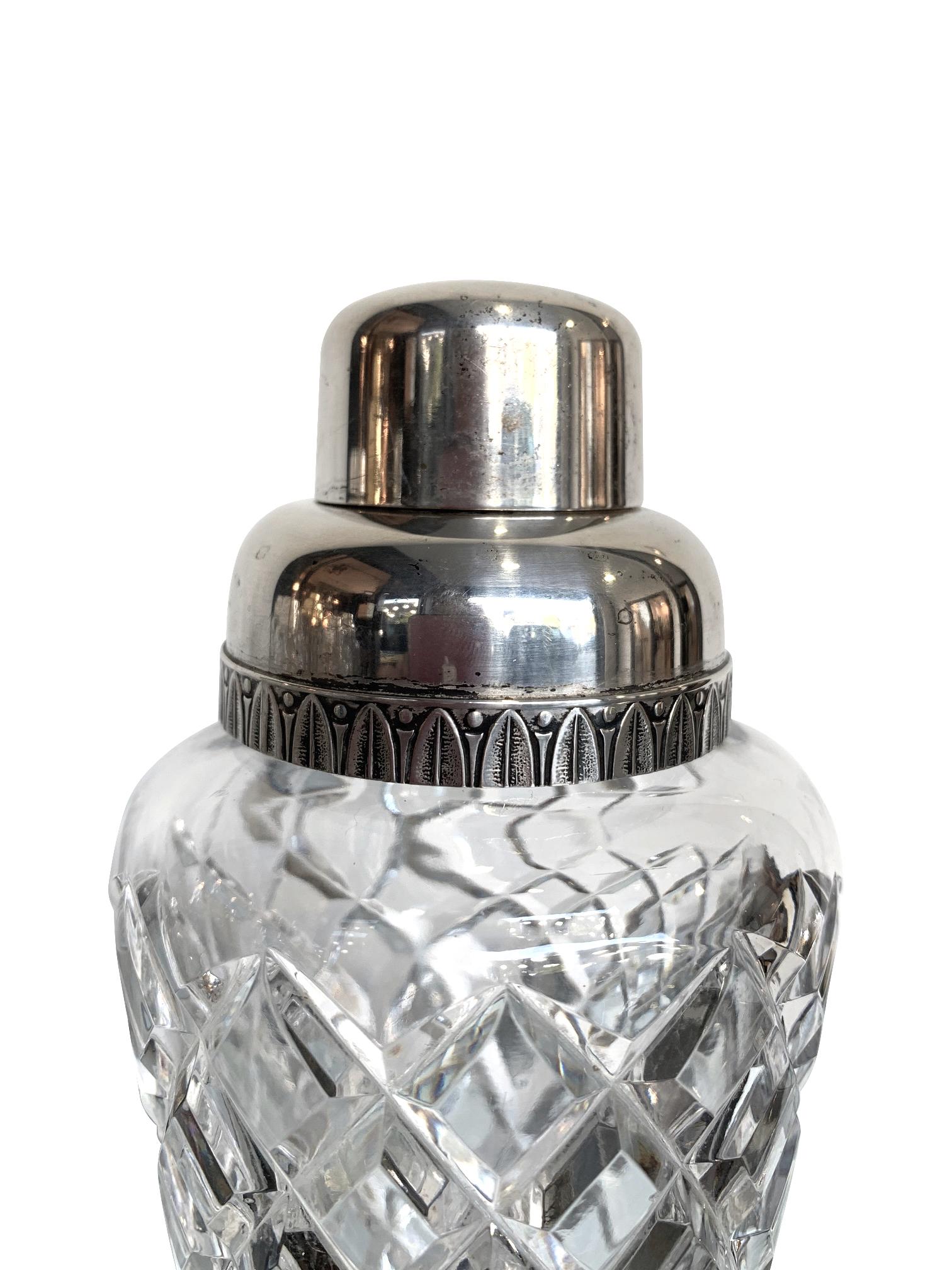 A 1950s crystal Val Saint Lambert cocktail shaker with silver plated top with leaf detail around the top.