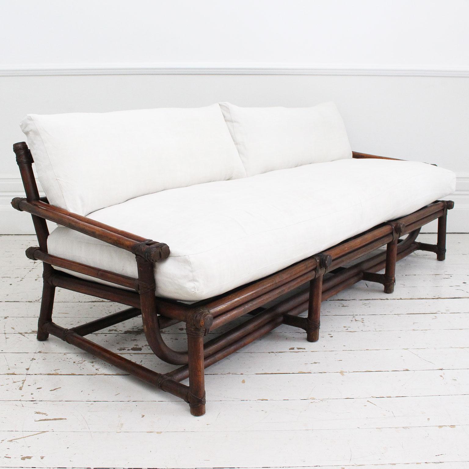 This mid century French dark bamboo sofa is wonderfully comfortable and chic. It can be used inside covered with soft hides or outside. We love the elegant curves and the leather wrap detail. Charlotte has made luxurious, feather filled antique