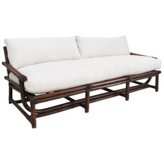 A 1950's French Dark Bamboo Sofa with Antique Linen Cushions