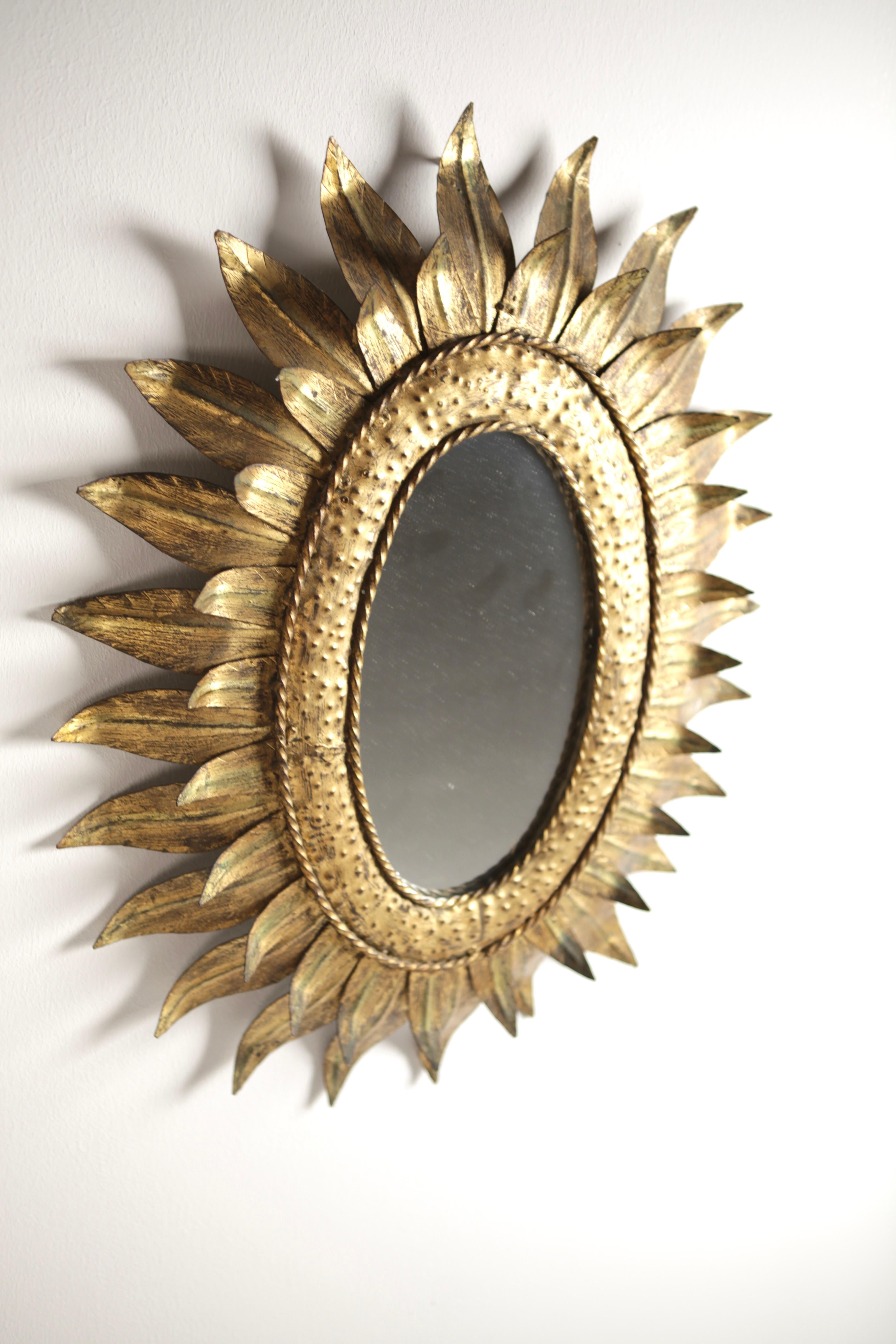 A beautiful oval shaped sunburst mirror with gilt leaves in two sizes.
Very nice aged patina, handcrafted in Spain in the 1950s.
