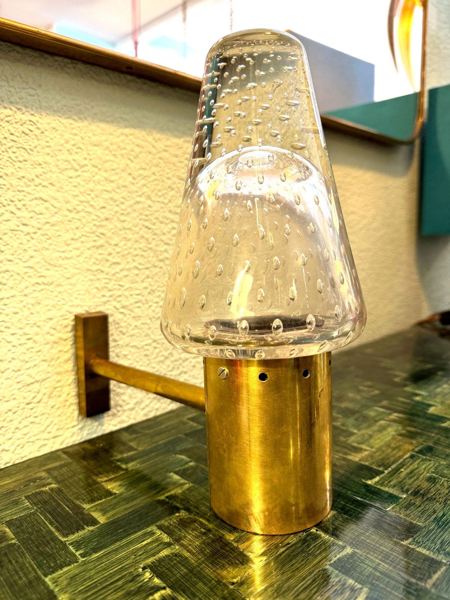 Raro aplique de cristal de Murano y latón de los años 50 diseñado por Gino Sarfatti y Archimede Seguso,  para la empresa de iluminación Arteluce. 
Con brazo de latón y soporte de pared y collar que sujeta los herrajes sobre una pantalla de cristal