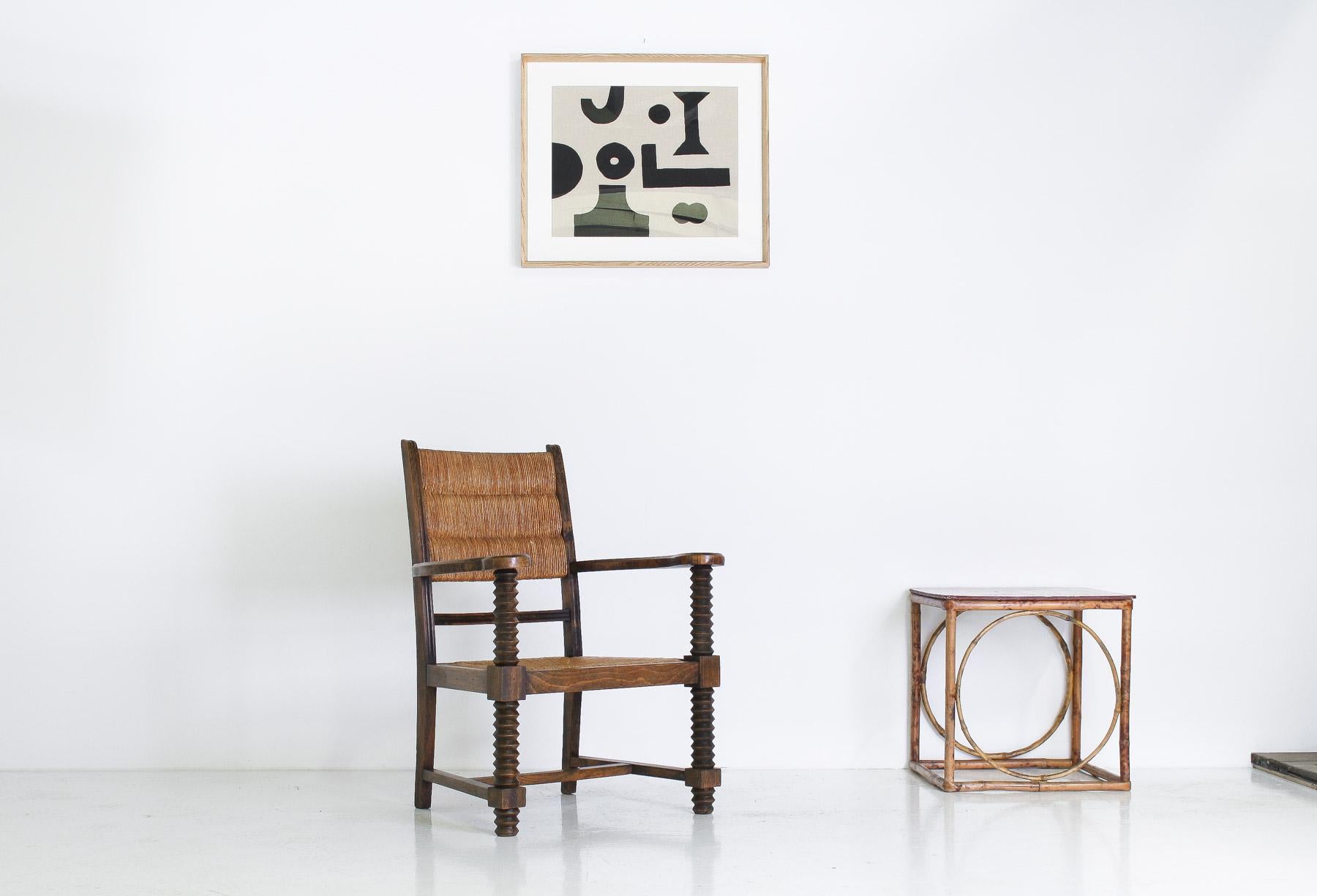 Fauteuil conçu par le célèbre fabricant de meubles français Charles Dudouyt dans les années 1940. La chaise présente les emblématiques pieds tournés en forme de tire-bouchon d'Icone, ainsi qu'une assise et un dossier en jonc. La construction et les