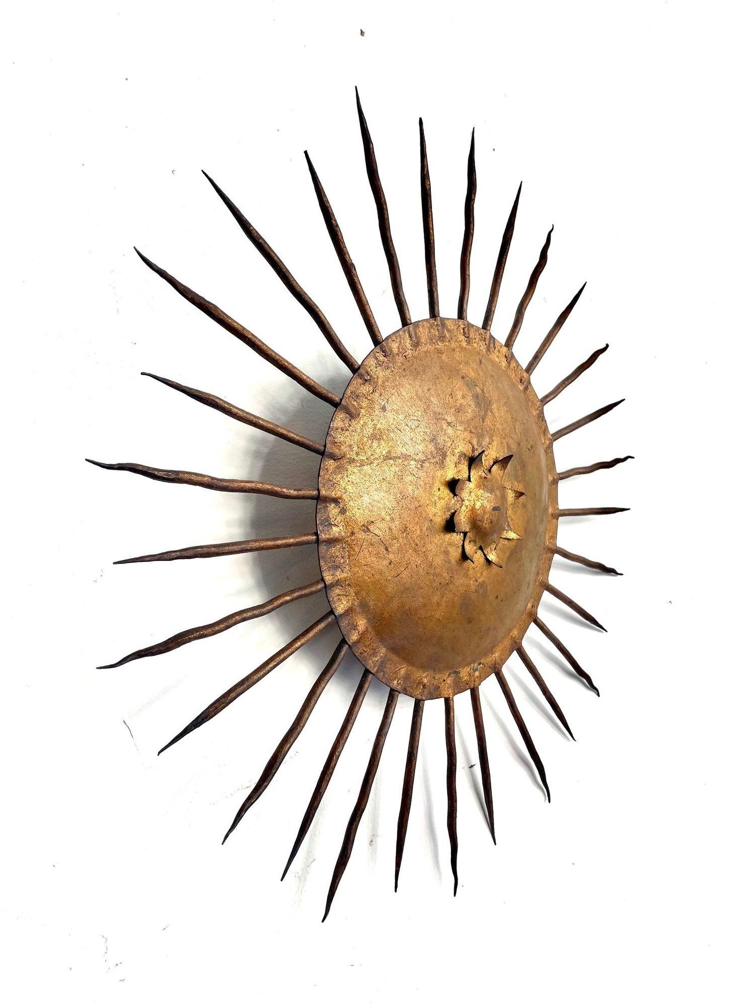 A 1950s Spanish wrought iron sunburst wall sconce with gilt finish and three light fitting behind, re wired and PAT tested.
This could be used as a wall or ceiling light an there are others avaiable inn differing styles which could create a