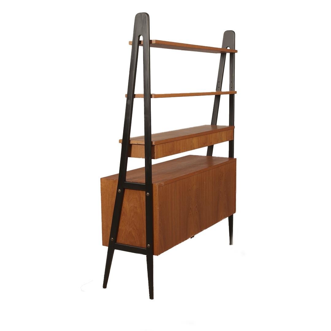 Libreria scandinava in teak con cassetti e piano scrivania, realizzata in teak e legno laccato nero. Questo pezzo multifunzionale combina spazio di archiviazione e spazio di lavoro in una straordinaria silhouette architettonica. La base presenta