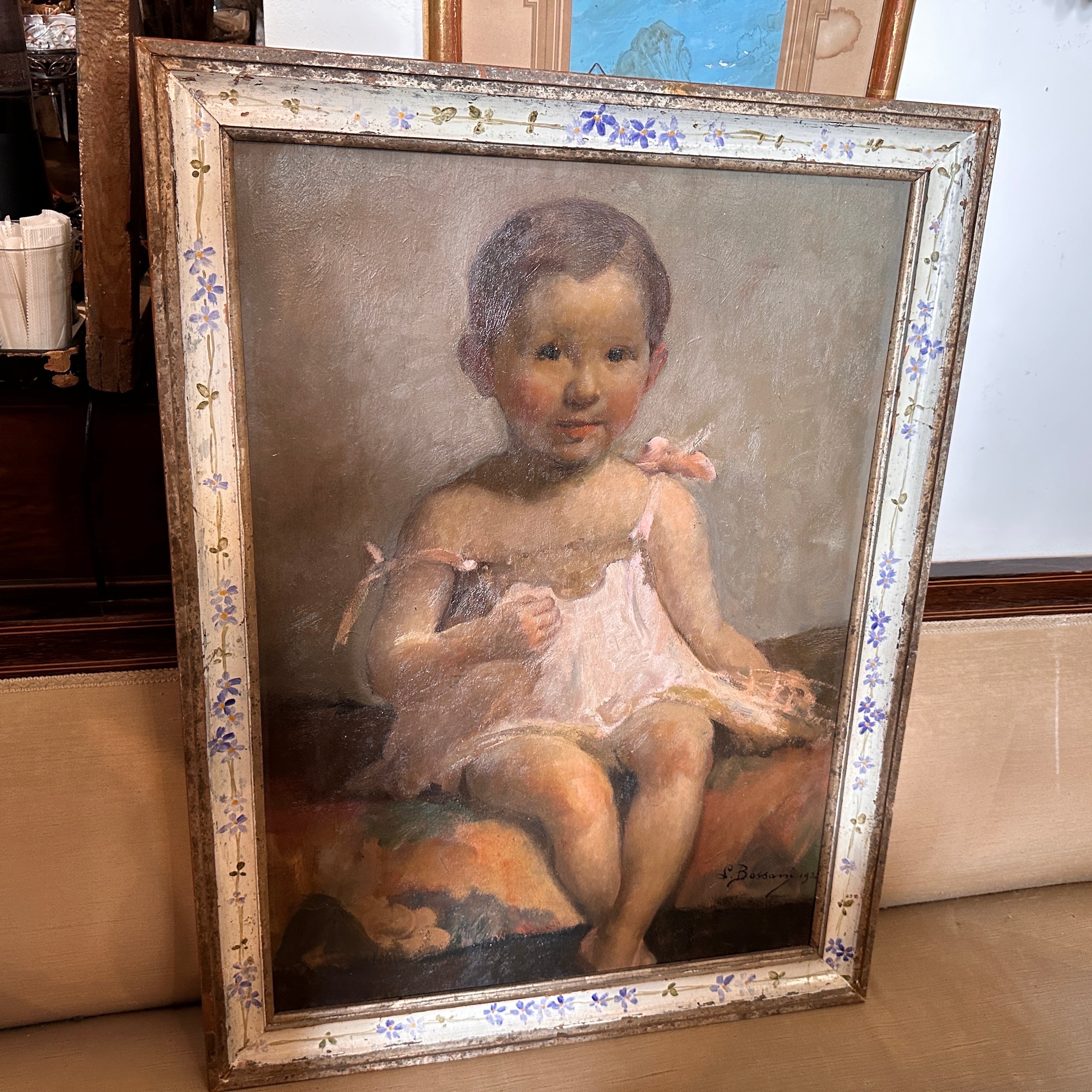 In 1952, the talented Italian artist Lucia Bassani created a captivating portrait on plywood of a little girl that continues to enchant viewers with its tender portrayal and skillful execution. The painting features a young girl, likely around the