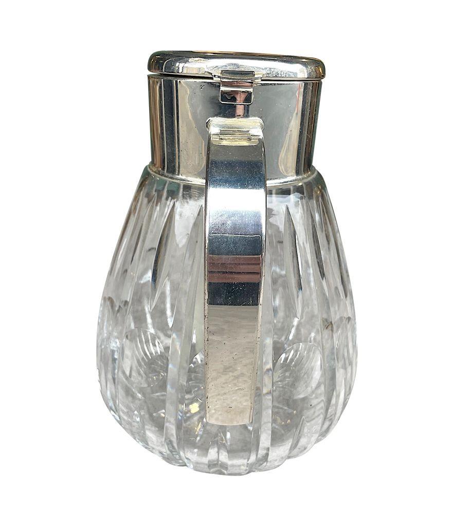 A 1960s German, crystal and silver plated lemonade jug with central ice tube, hinged lid and handle. Stamped on the lid 