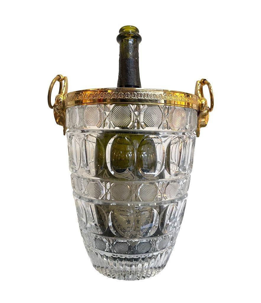 A 1960s Val St Lambert style glass champagne bucket with oval and cross hatch detail with gilt metal ram head handles and rim.