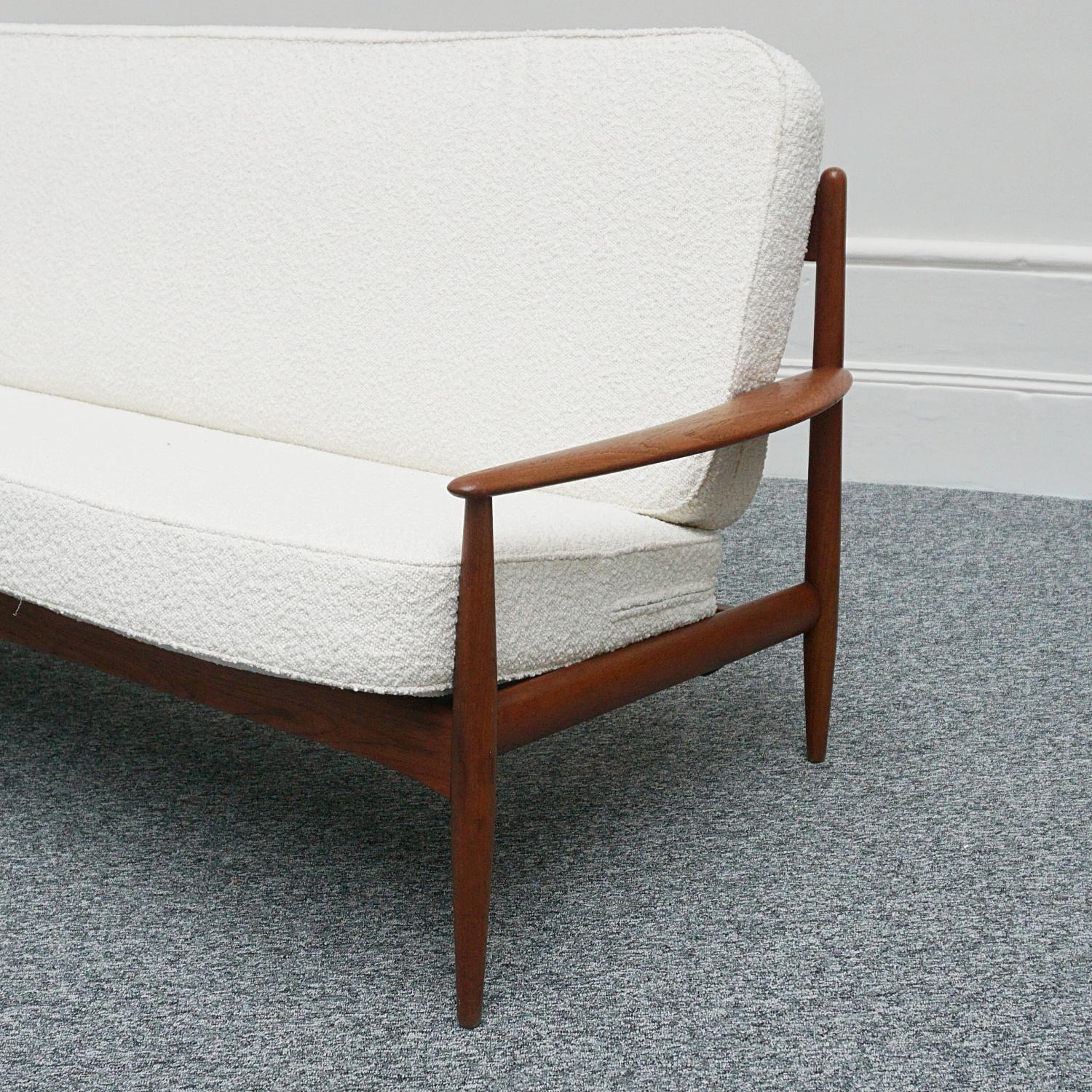 A mid-century sofa designed by Grete Jalk for France & Son. Teak framed with curved arms and original label to inside of seat. Original cushions re-upholsted in white Bouclé. France and Son Label is earliest of the France & Son era post France &