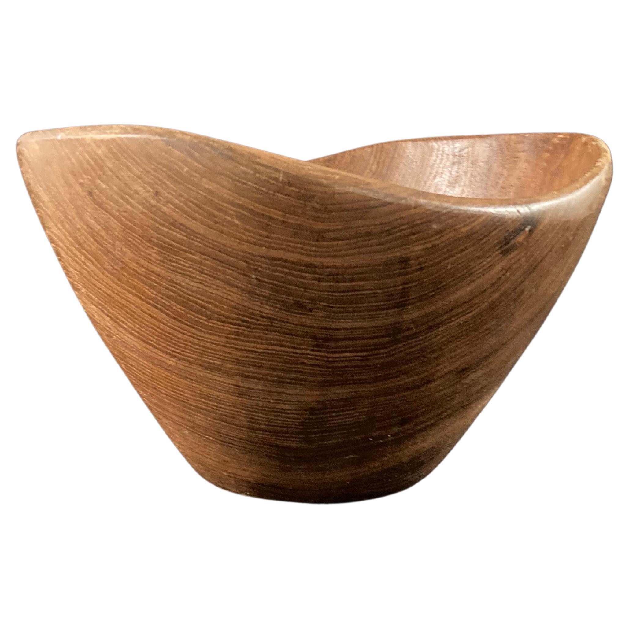 A 1960s Scandinavian teak bowl in the style of Jens Quistgaard.
The undulating rim and grain of wood give it a wonderfully natural and warm look. 

Danish sculptor and industrial designer Jens Quistgaard (1919–2008) enjoyed a long and successful