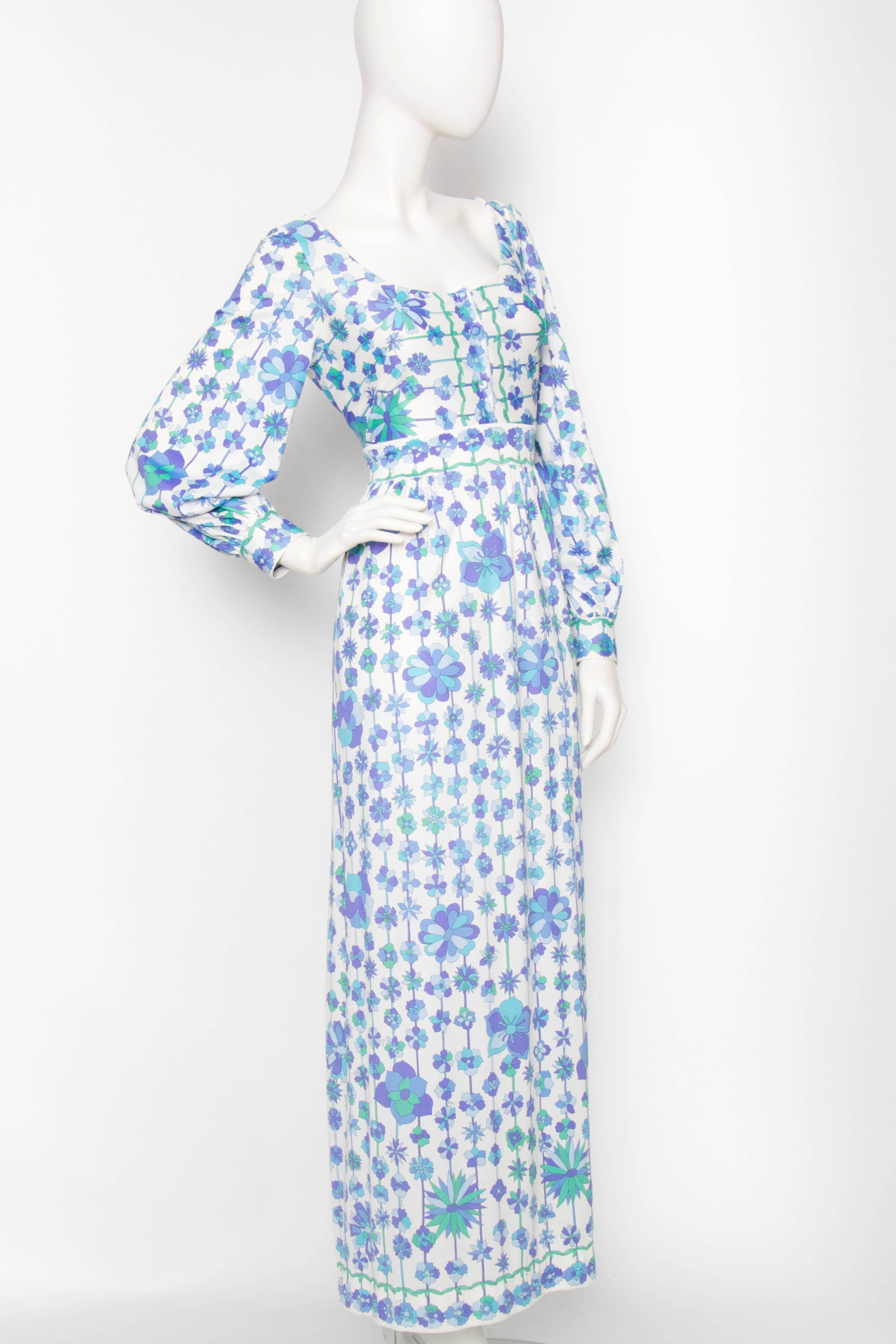 A lovely late 1960s Emilio Pucci for Formfit Rogers white maxi dress with characteristic purple, blue and green flowers. The dress has a round neckline, a button-down front and long sleeves with fitted cuffs. The dress is unlined. 

The size of the