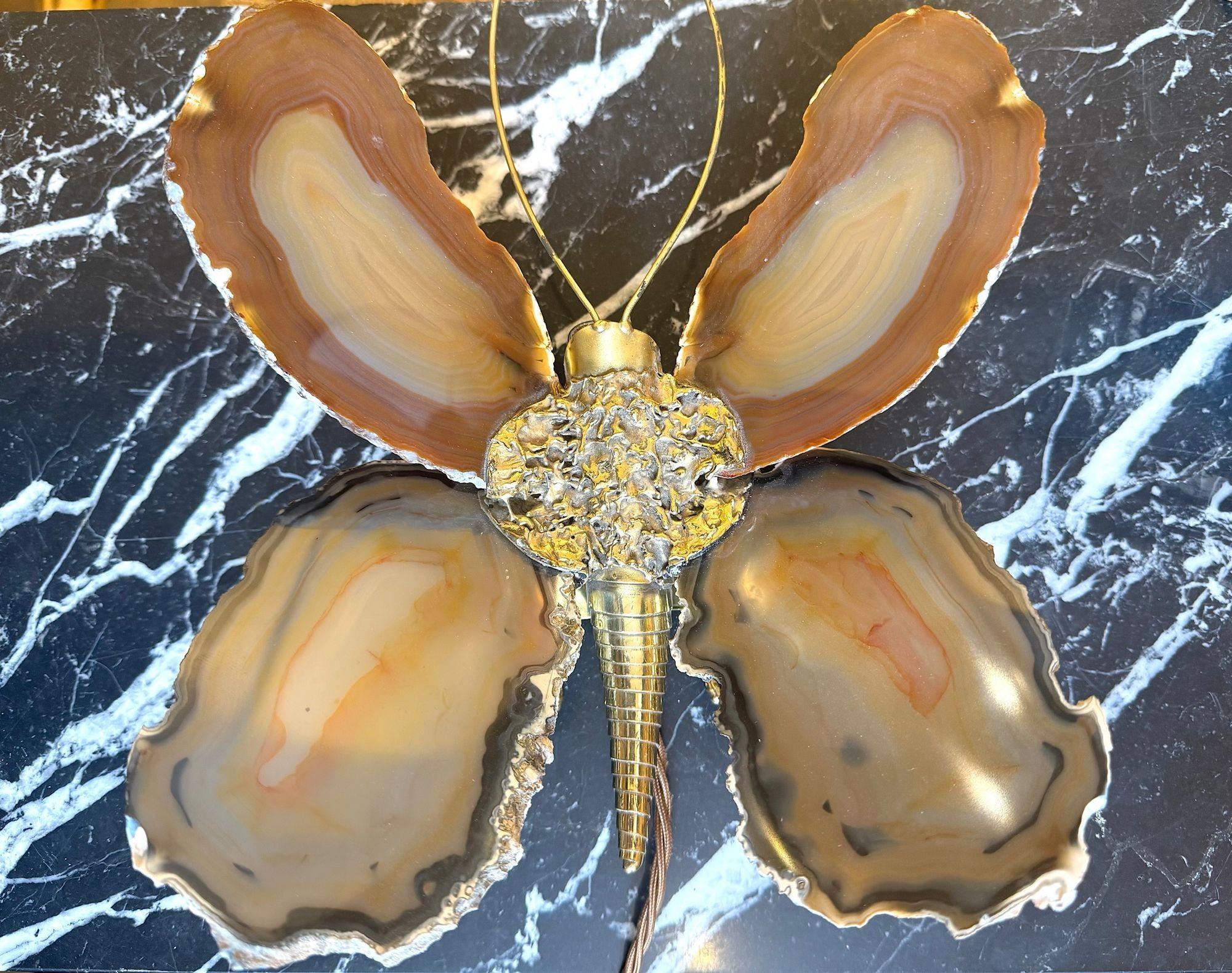 A wonderful 1970s agate and brass butterfly wall light sculpture by Isabelle Faure with 3 light fittings 2 behind the lower agate wing pieces and one under the head, that illuminate giving a soft orange glow. Re wired with new fittings, antique gold