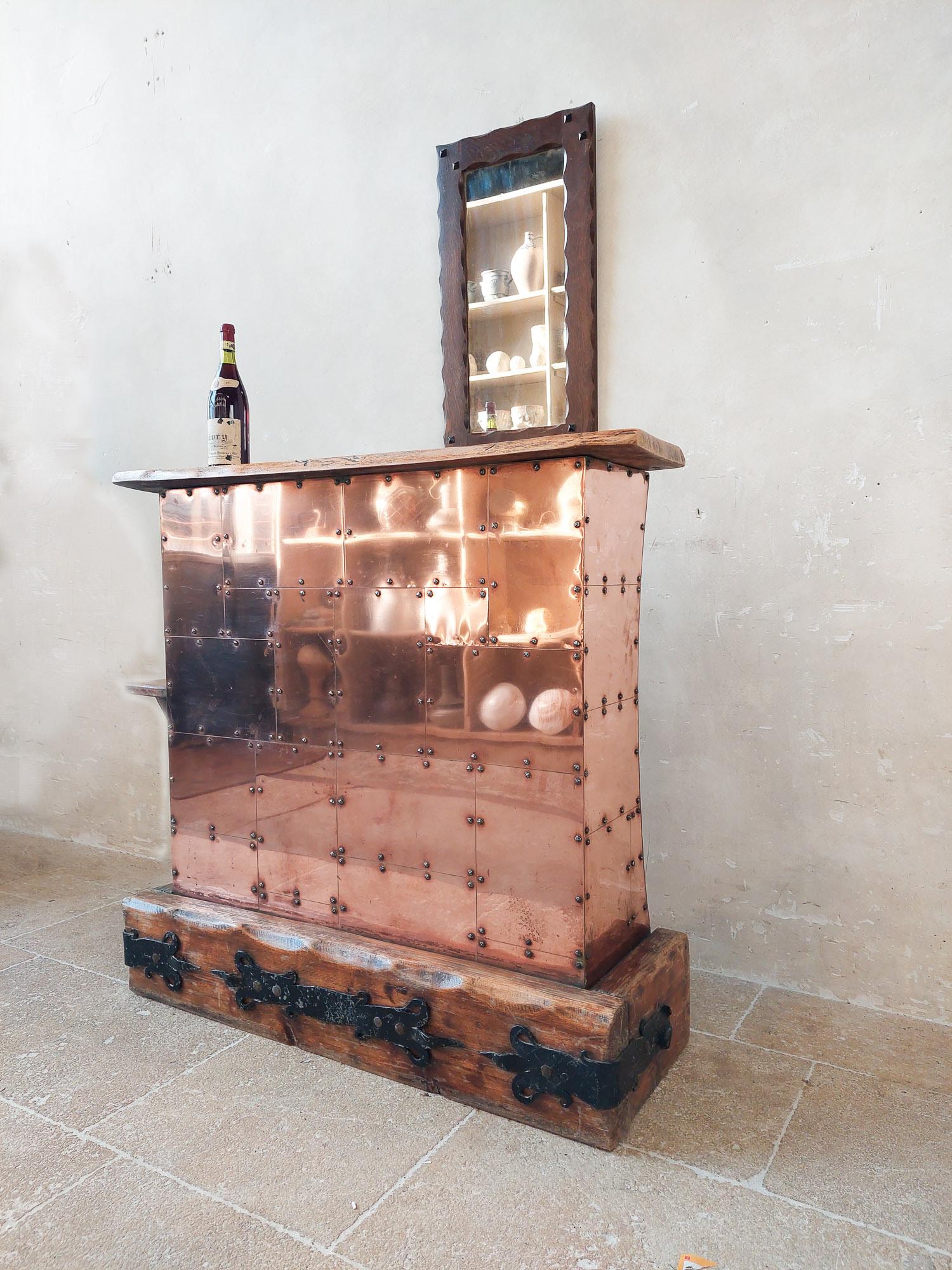 A 1970s bar with rivited copper clad. The top and bottom of this homebar have a thick piece of oak, on the bottom part are decorative wall anchors attached.

On the backside there are three shelves and the inside lined with red fabric.

h 110 x