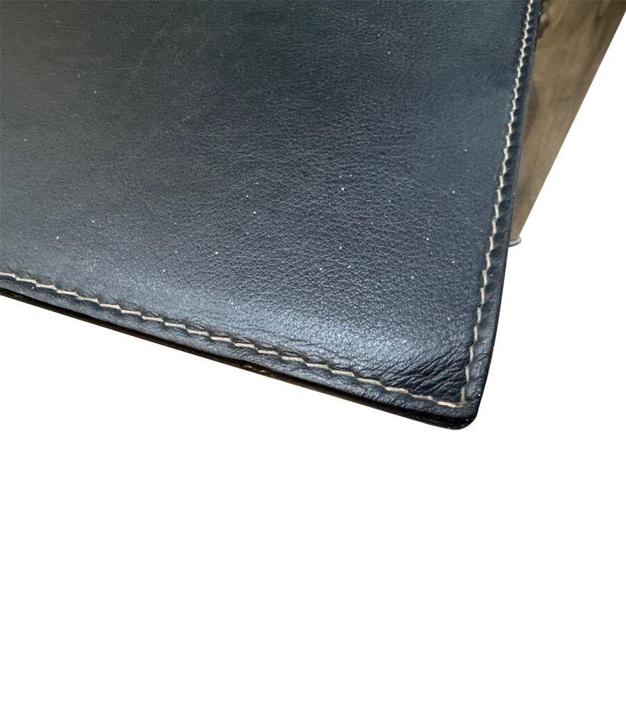 Une table basse en cuir noir surpiqué des années 1970 