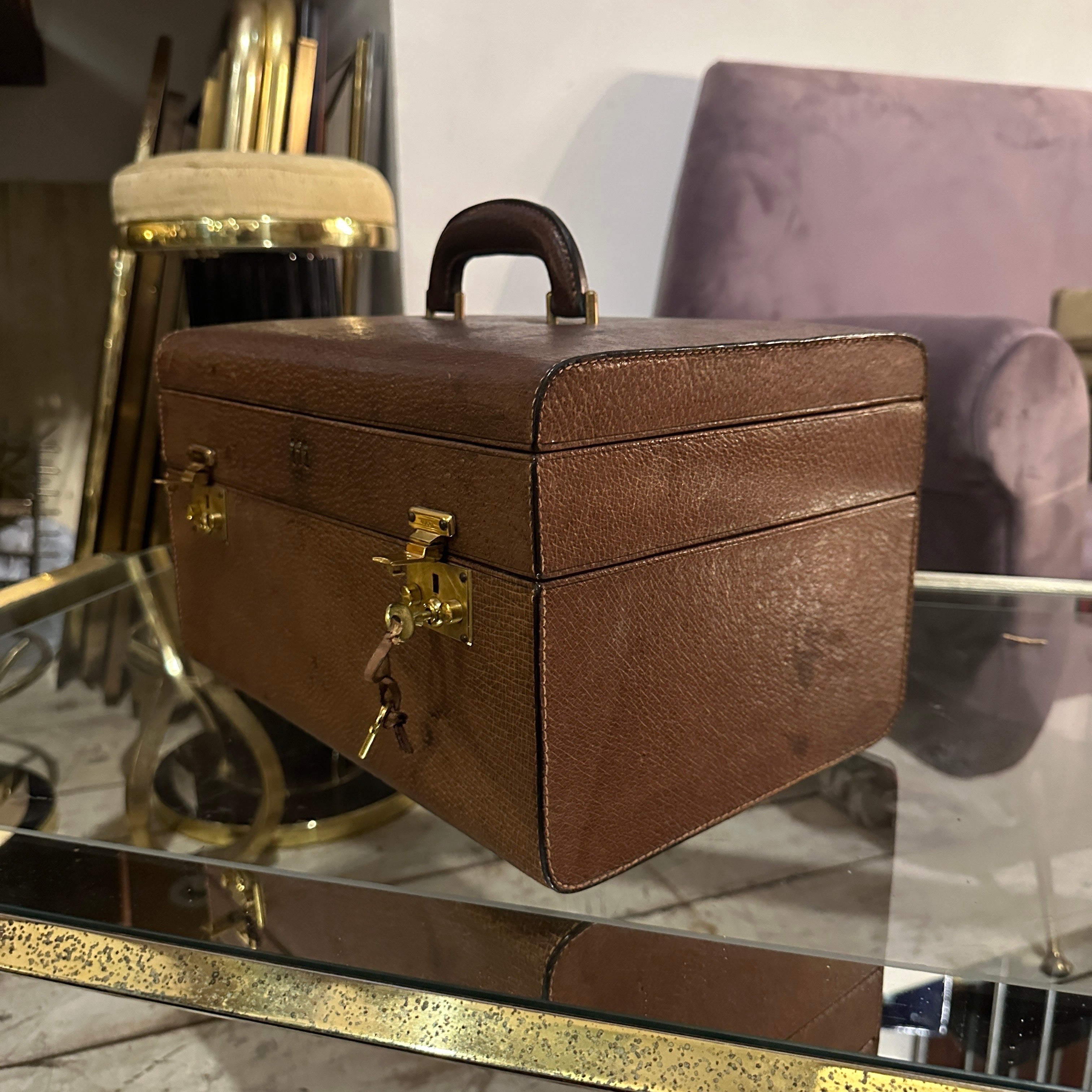 This exquisite brown leather beauty case by Gucci is a quintessential example of timeless luxury and exceptional craftsmanship. Made from rich, high-quality leather, the case showcases a classic, structured design with a smooth finish that exudes