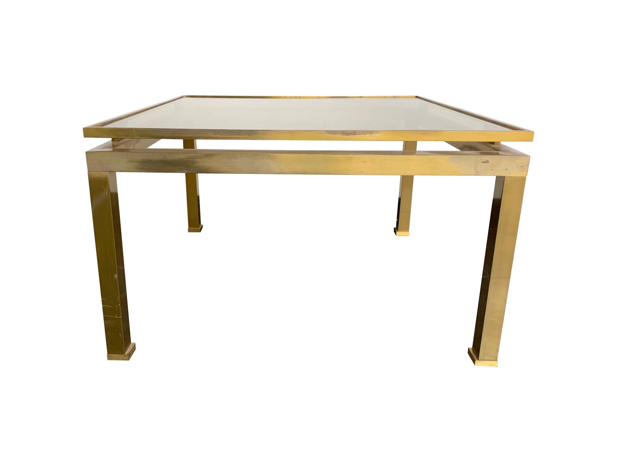 A 1970s original Guy Lefevre solid brass side table with characteristic floating top with smoked glass top and chinoiserie style foot detail. From the 