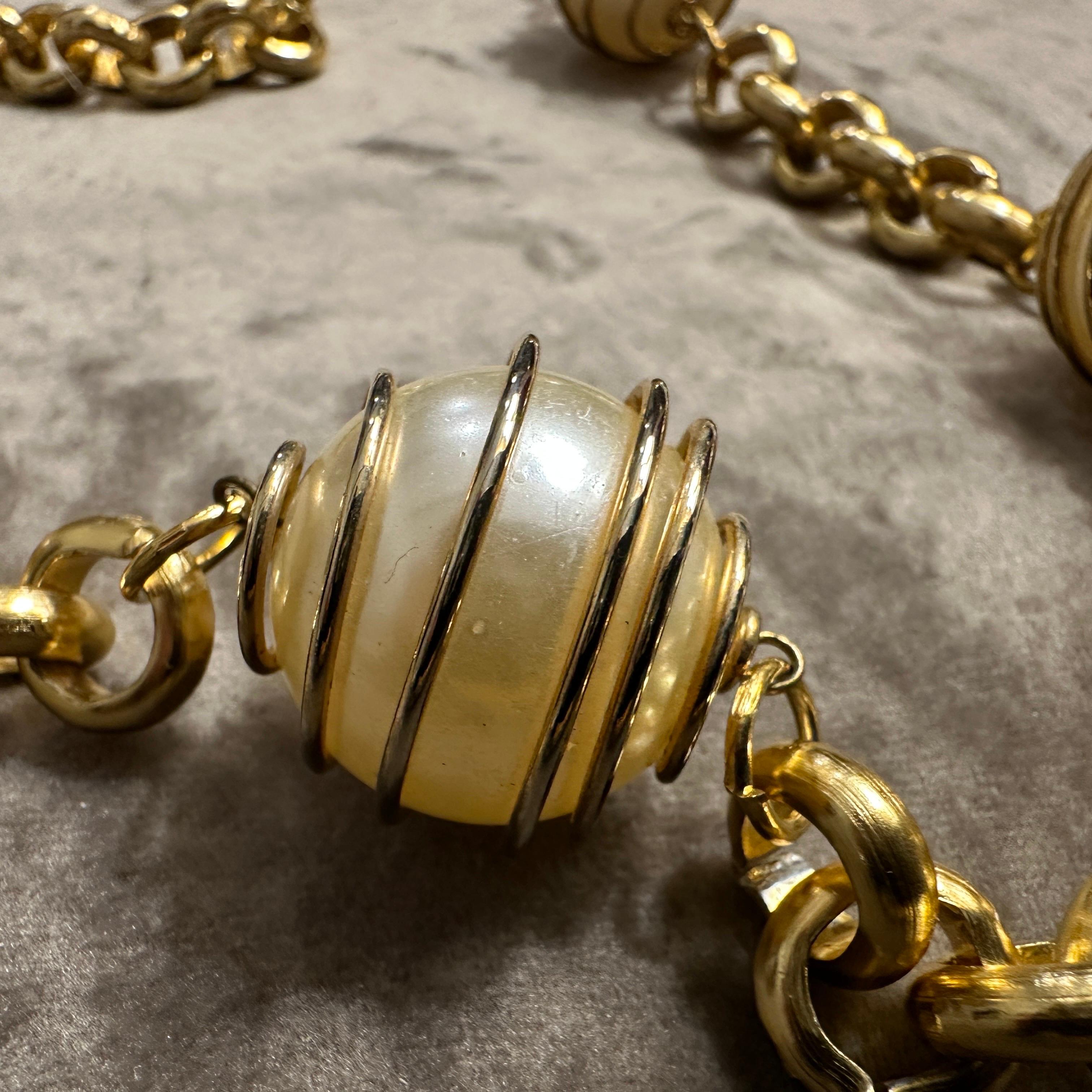 This is a vintage Italian high-quality necklace featuring a striking combination of faux pearls and a brass chain. The design consists of a sturdy, polished brass chain with interlinked oval links, offering both elegance and durability. Interspersed