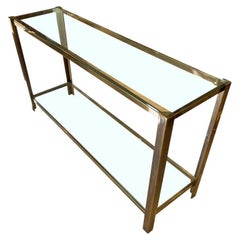 A 1970s Italian solid brass console table with 2 glass shelves