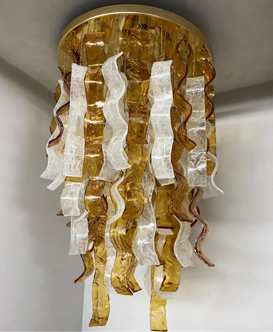 An amazing brown and clear murano glass cascading chandelier designed and manufactured by Mazzega in the Seventies, it comes from an important lighting shop that was going out of business, so it has never been installed in a home and therefore works
