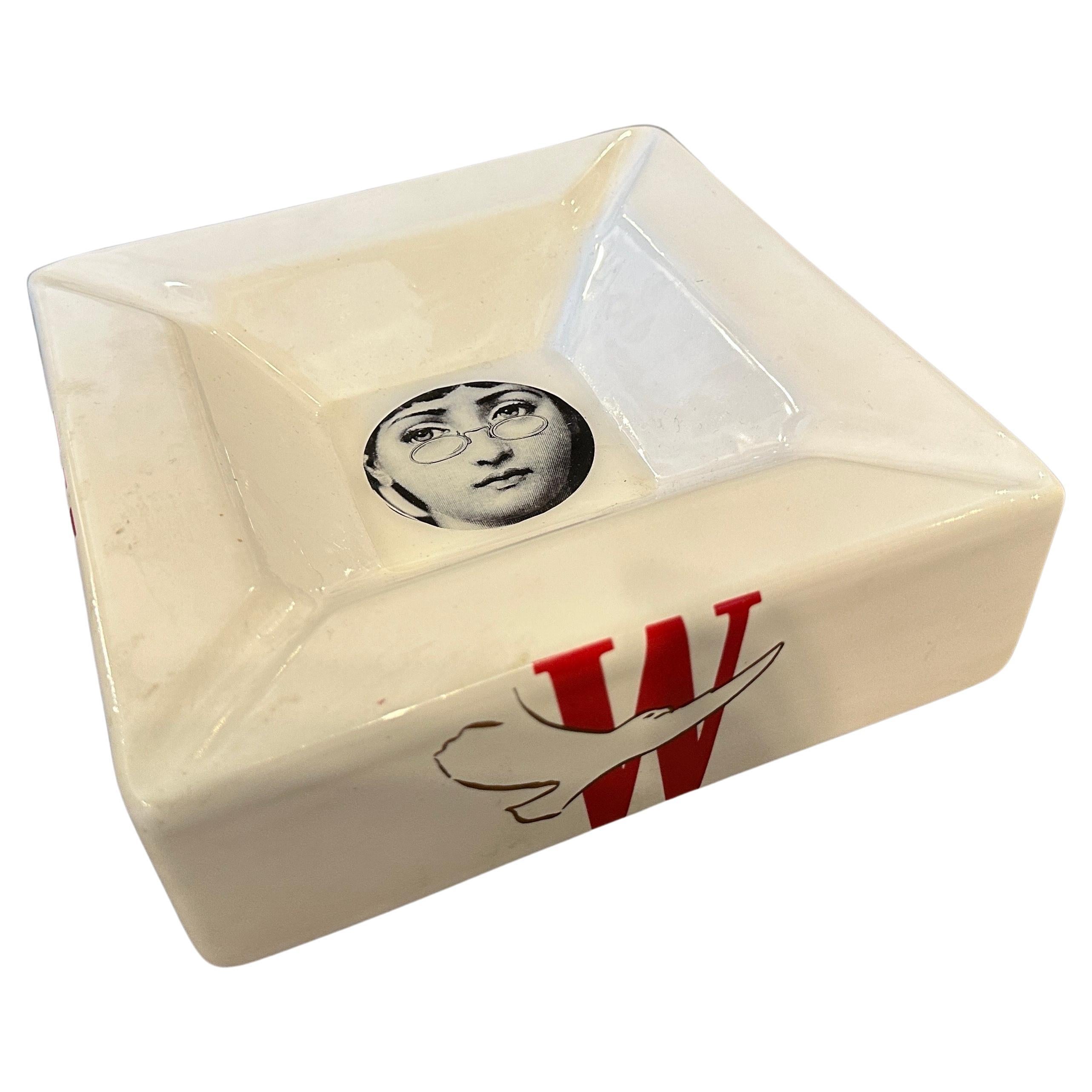 A square white ceramic ashtray designed and manufactured by Fornasetti for Winston cigarettes, it features the famous woman's face that we see in many variations of her iconic illustrations, the opera singer Lina Cavalieri. It's in lovely