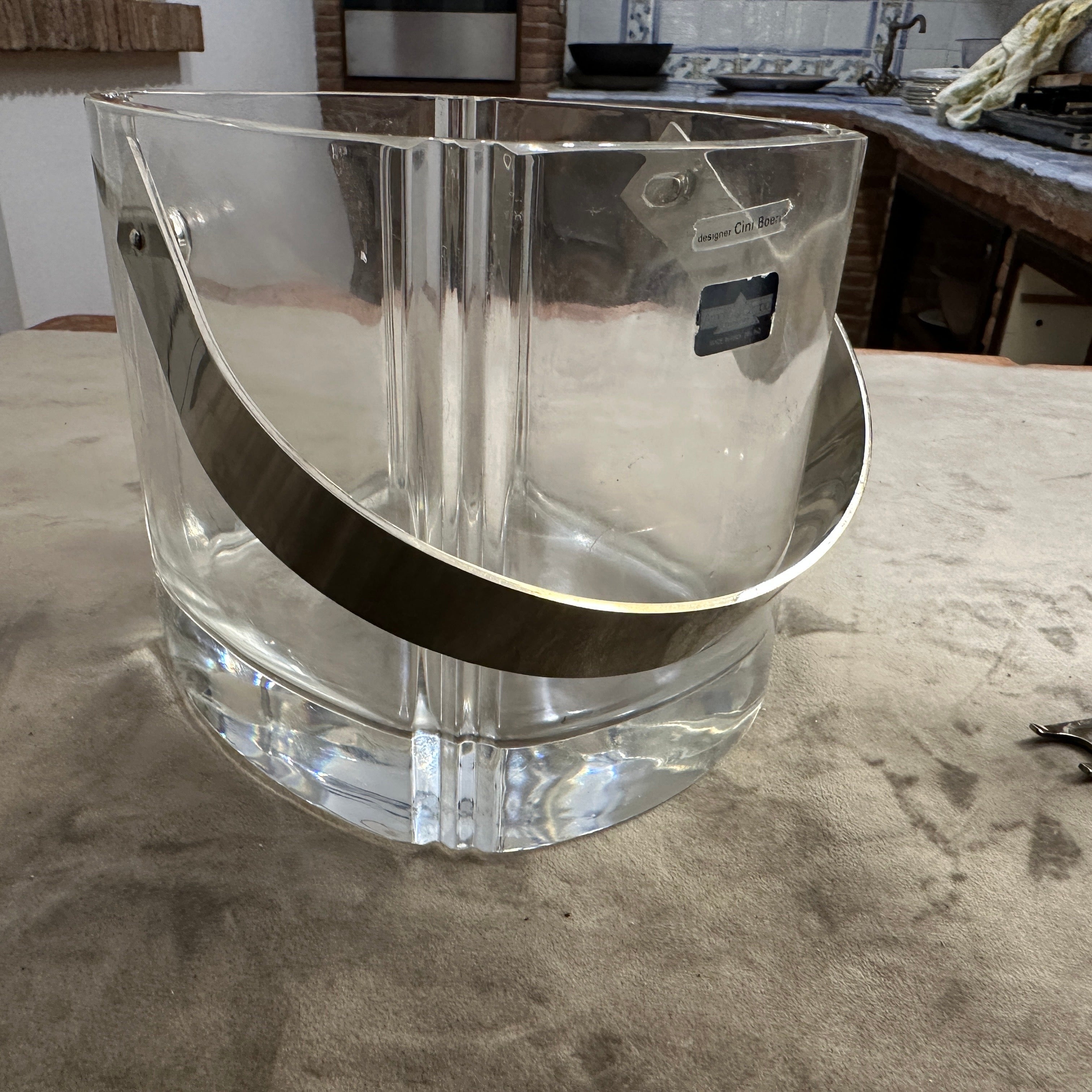 Ce seau à glace moderne en cristal lourd des années 1970 est un exemple étonnant de design italien créé par CINI Boeri pour Christofle di Cambio, associé à l'élégante pince à glace de Lino Sabattini par Christofle.
Verre de cristal épais de haute