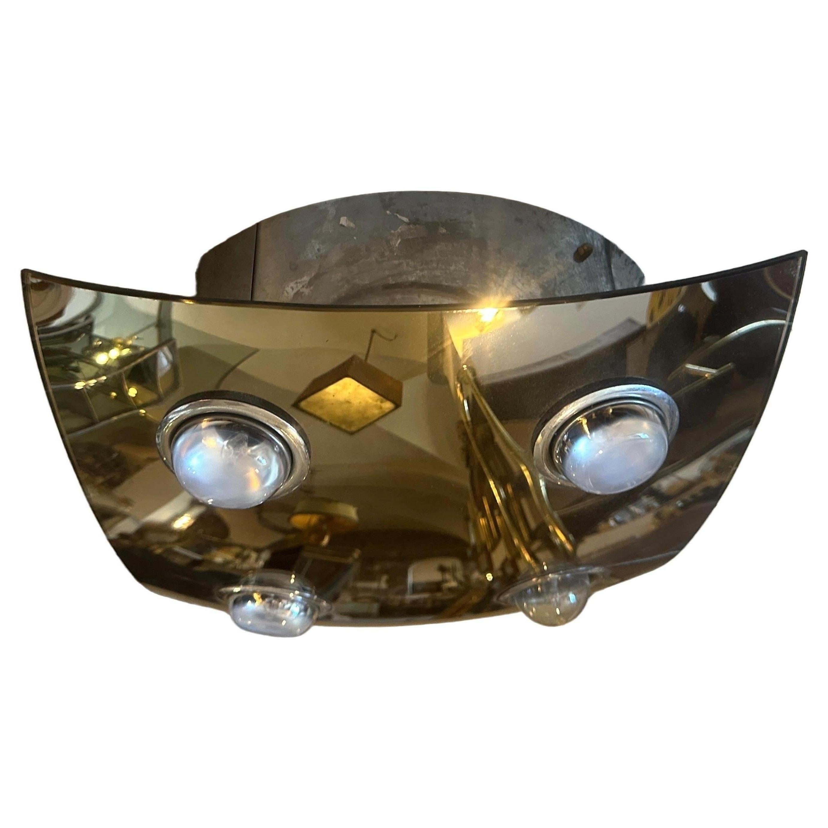 A square four lights lighting fixture designed and manufactured in Italy in the Seventies by Veca, the curved smoked mirrored glass it's in perfect conditions. This Italian Ceiling Light by Veca encapsulates the essence of its time, showcasing a