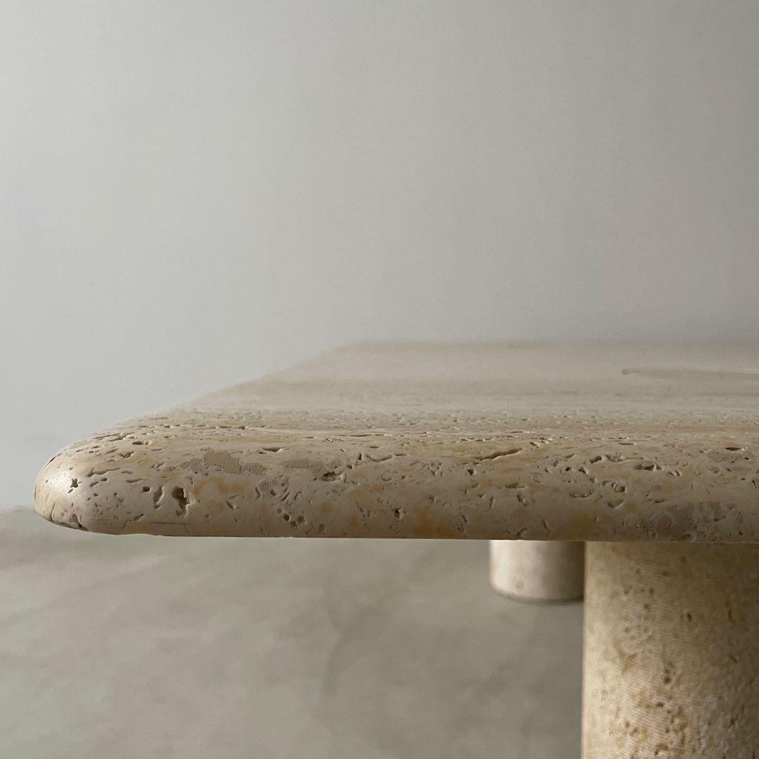 A large square travertine coffee table designed by legendary architect and industrial designer Angelo Mangiarotti and manufactured by Up&Up Italy in the 1970s. 

The honed travertine top is crafted from one piece of stone and features rounded
