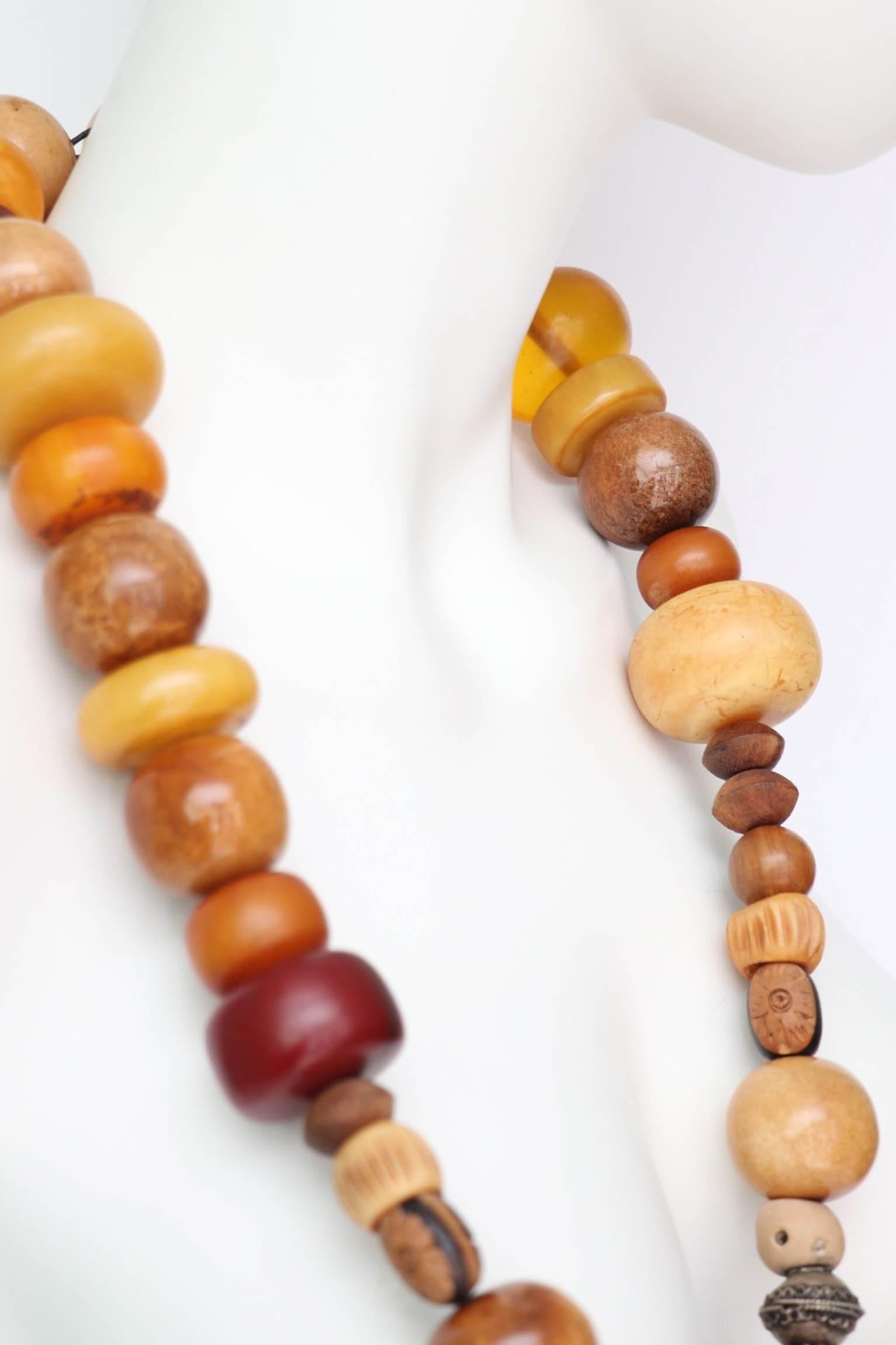 A stunning 1970s heavily beaded necklace consisting of several large beads of both amber and wood. The beads have different shapes, sizes and various colours. 
The necklace is set on an elastic string and is tied at the back. 