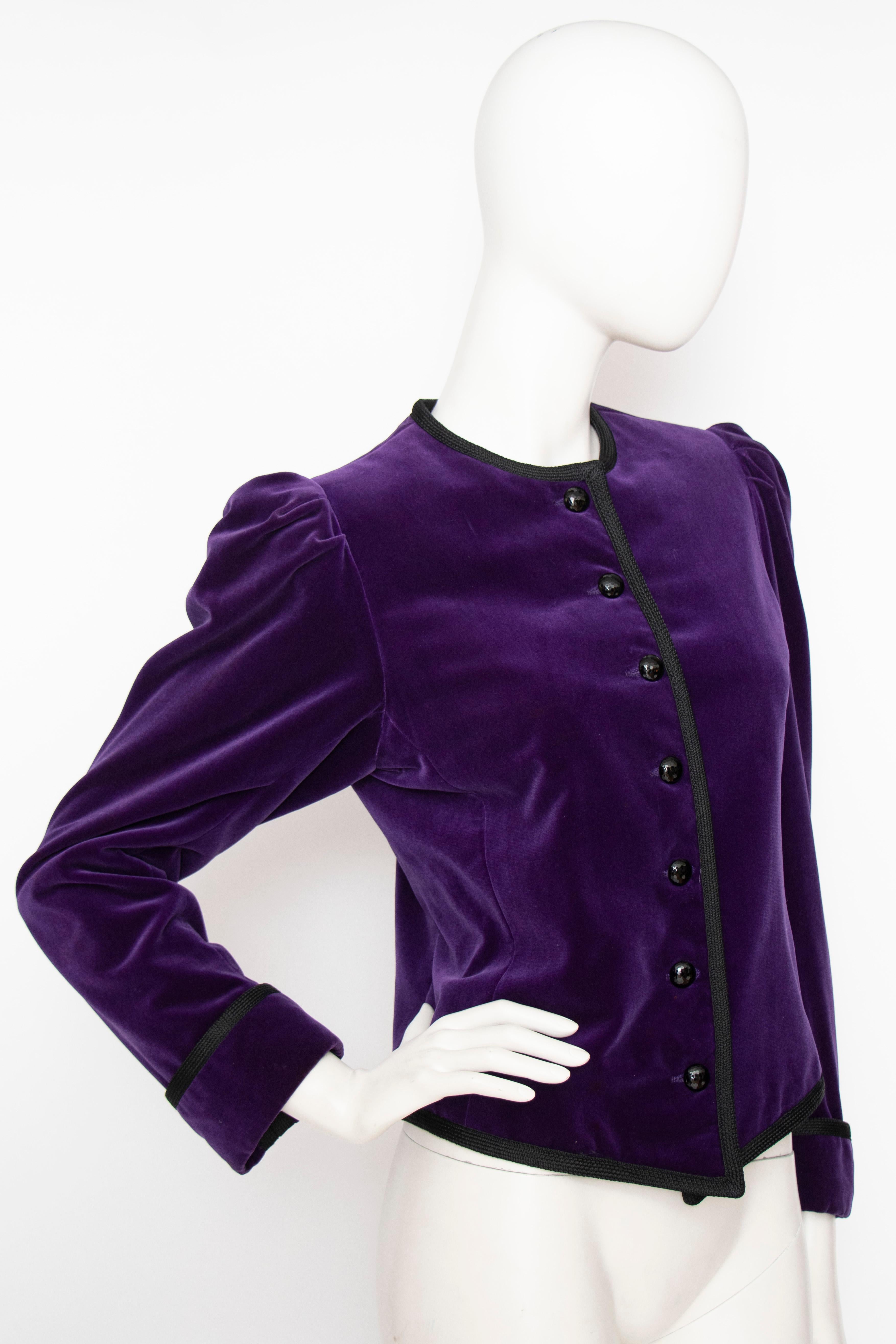 A 1970s vintage Yves Saint Laurent Rive Gauche purple velvet jacket with black facetted buttons, puffed shoulders and black trim detailing. 

The jacket is fully lined and the size corresponds to a modern size extra small. 

