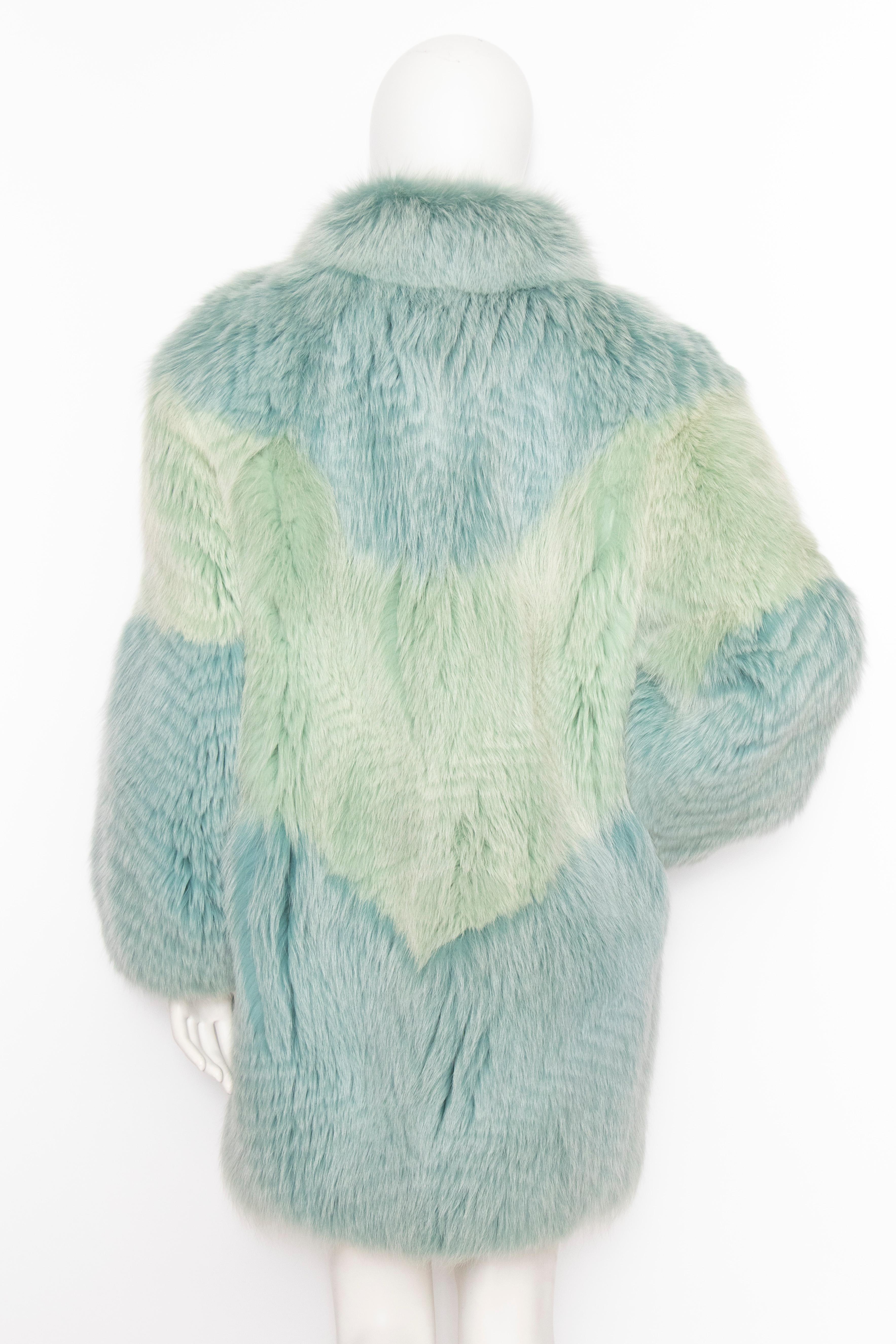 A fabulously extravagant 1980s dyed fox fur coat with great volume and hook closure in front. The stunning colour combines mint green and blue. The coat is fully lined and has side pockets. 

The size of the coat corresponds to a modern size medium,