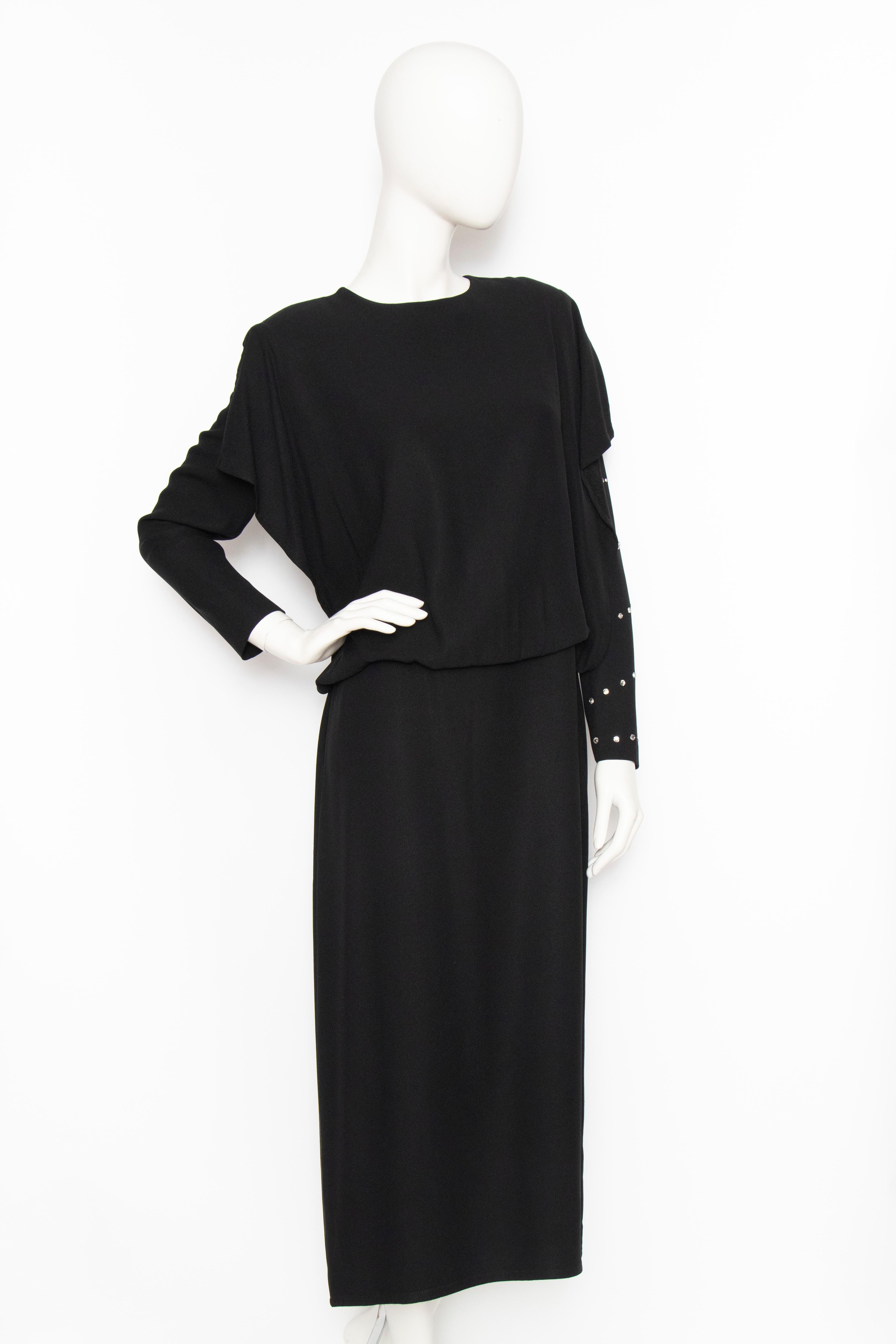 A 1980s Sonia Rykiel black viscose dress with a loosely fitted skirt and voluminous blouse with long sleeves. A single sleeve is encrusted with large rhinestones and the back has a push-button closure. The dress is unlined. 

The size of the dress