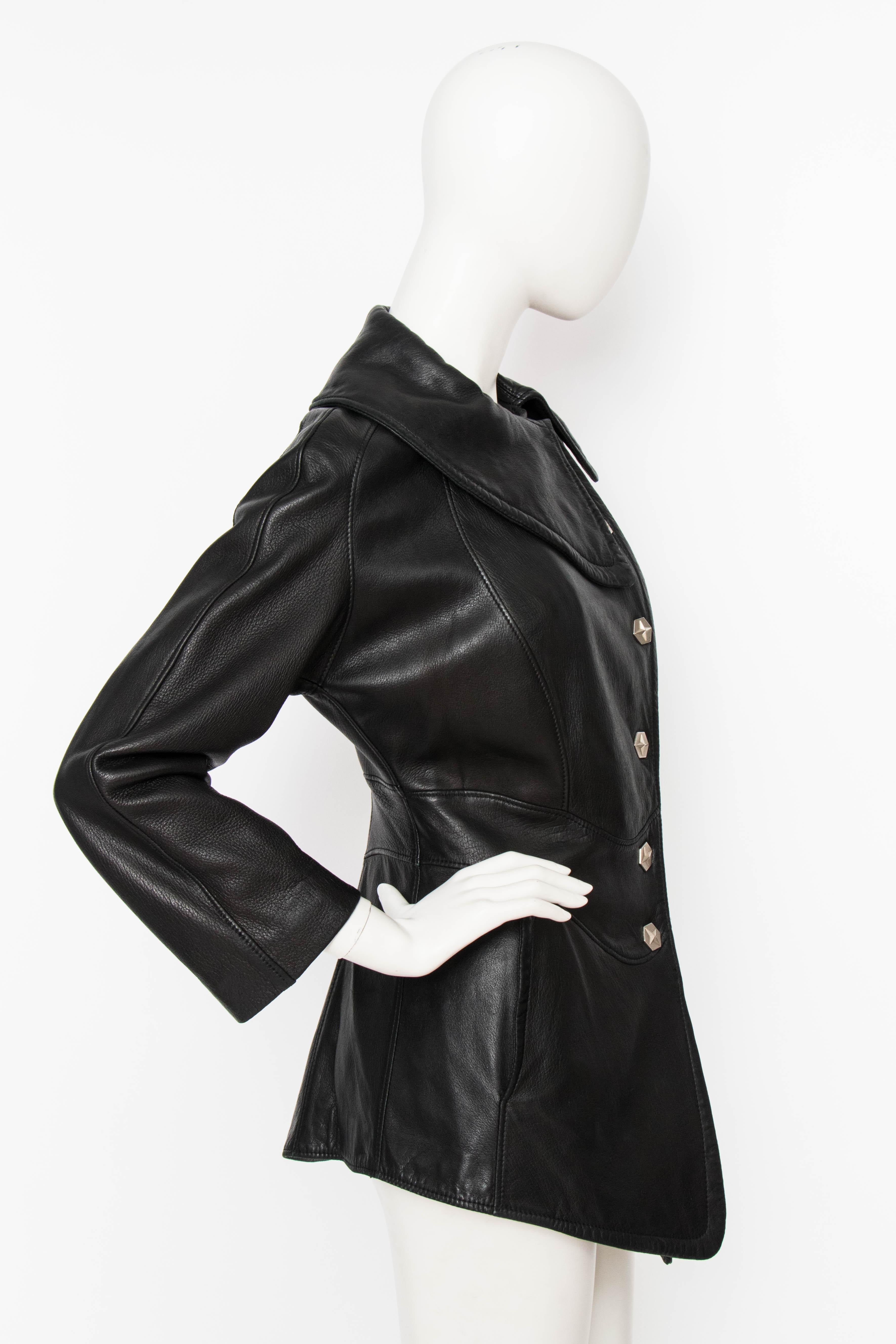 A 1980s Thierry Mugler Activ black leather jacket with an asymmetrical push button closure and a round asymmetrical collar. A horizontal panel accentuates the waistline and two vertical flap pockets are situated at the hip. The jacket is fully