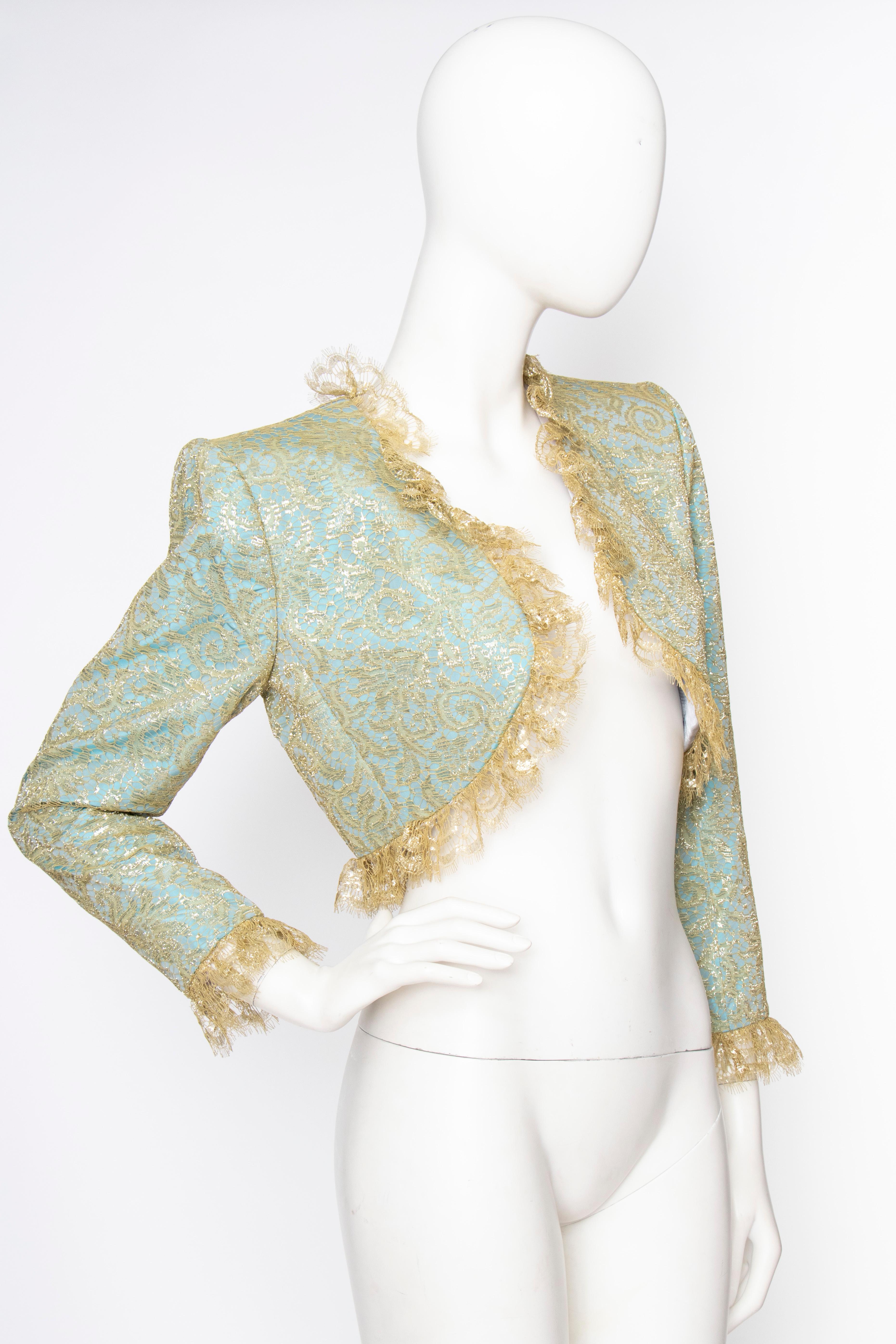 A glamorous 1980s Yves Saint Laurent Rive Gauche turquoise bolero jacket with fabulous shoulders, gold lace overlay and gold ruffle trim around the neck, open-front and cuffs. The jacket is fully lined. 

The size of the item corresponds to a modern