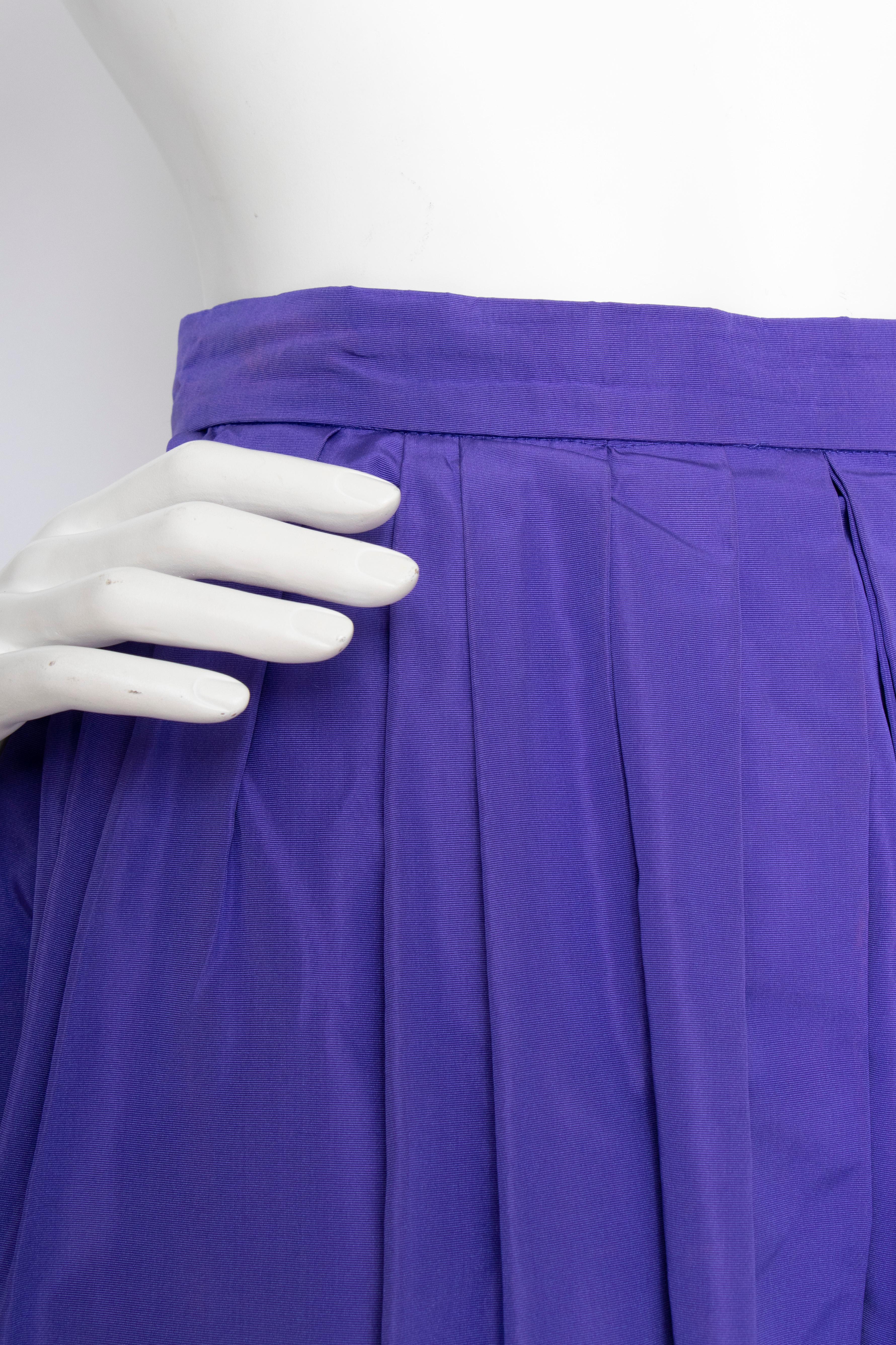 A 1980s Vintage Yves Saint Laurent Rive Gauche bold purple silk taffeta skirt with a fitted waist, zipper closure and large pleats. The skirt is unlined and has side pockets. 

The size of the skirt corresponds to a modern size Small, but please see