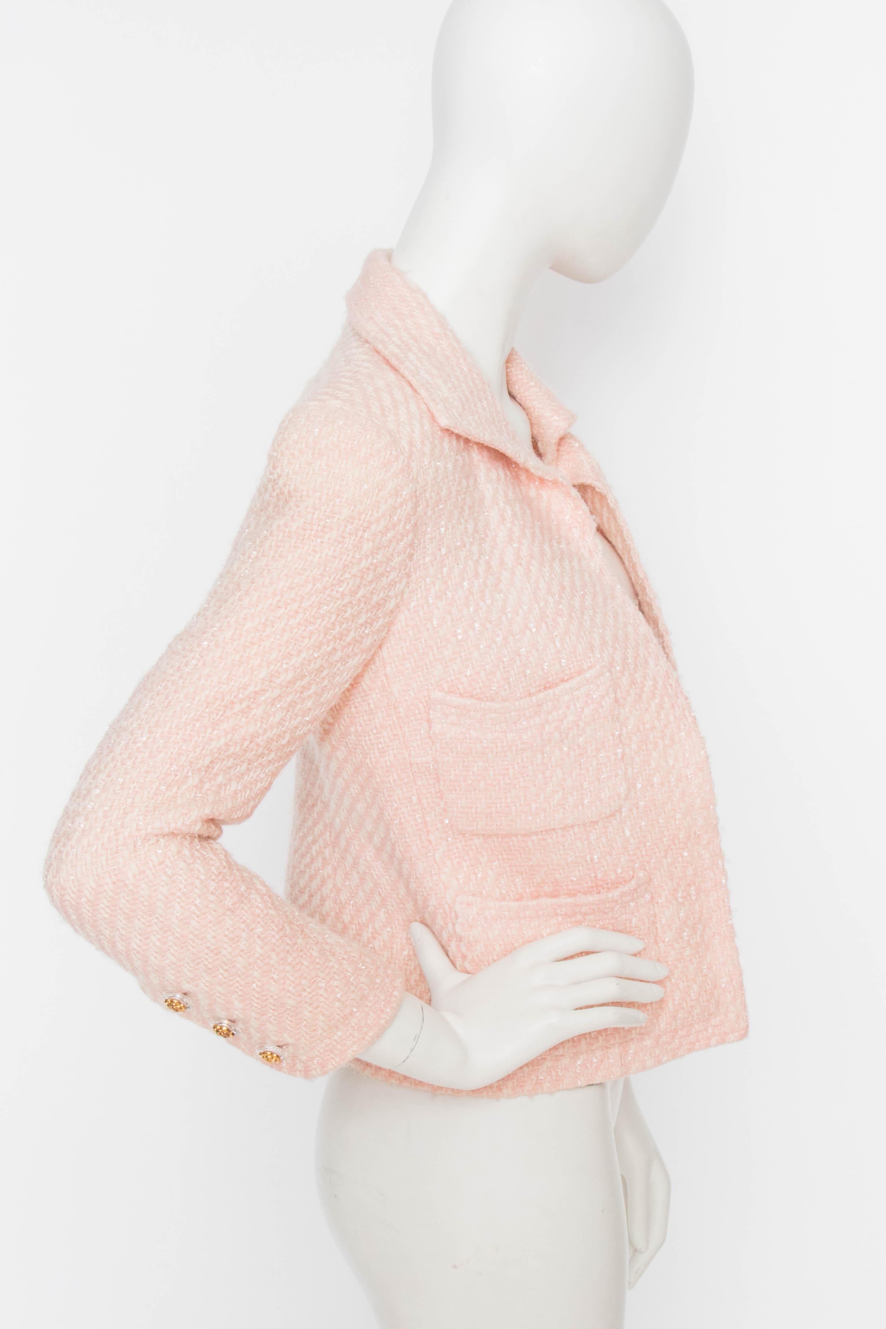A 1990s Chanel Pink Boucle jacket with an open front and a set of patch pockets on the breast and hip respectively.
The jacket is fully lined in matching pink silk with jacquard-woven double 'C' logo. A row of gold-toned Chanel rose buttons are set