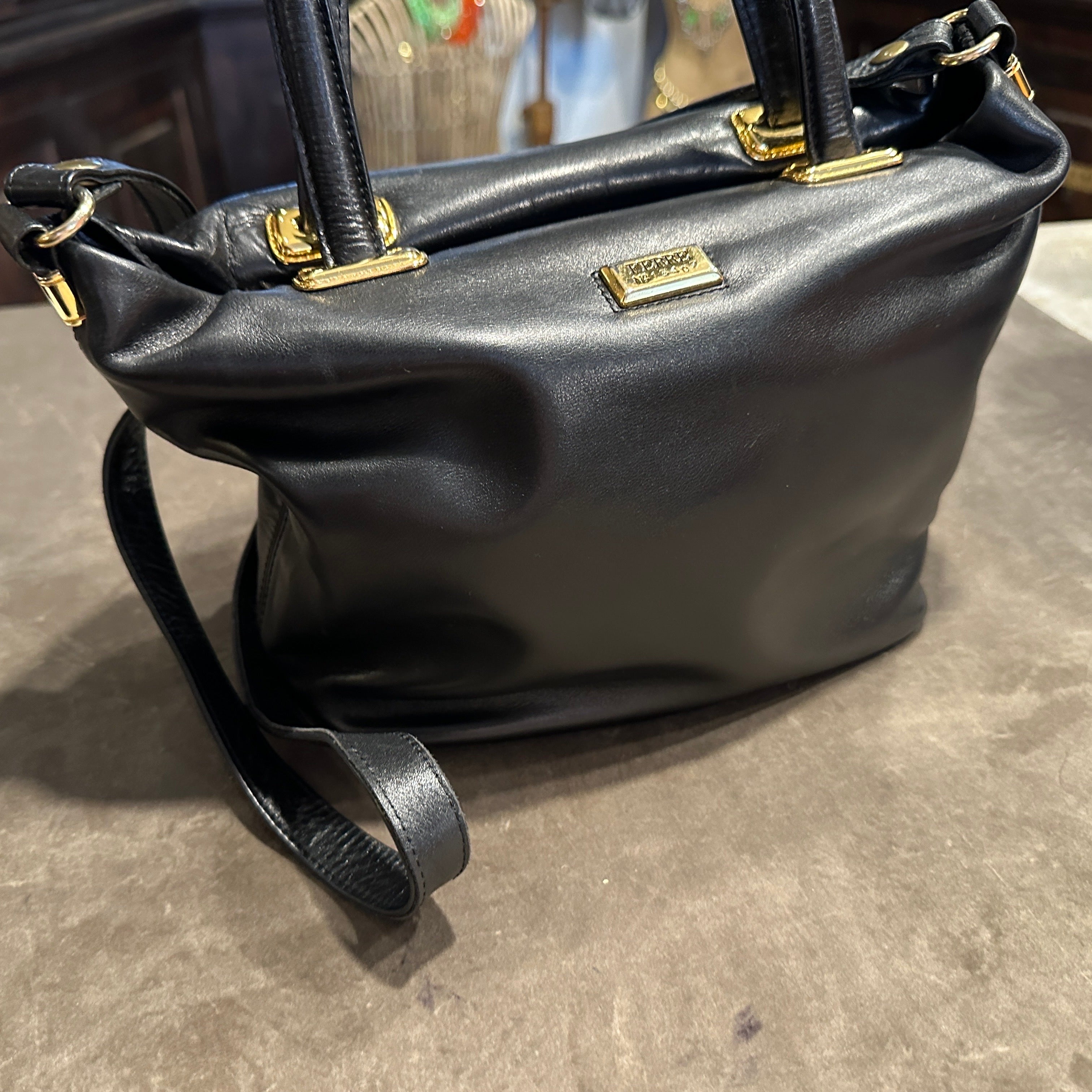 Elegant sac à main en cuir noir et laiton de Gianfranco Ferrè datant des années 1990
Réalisée en cuir noir souple, cette pièce élégante témoigne de la maîtrise par le célèbre designer italien d'un luxe discret et d'un savoir-faire impeccable.
Le sac
