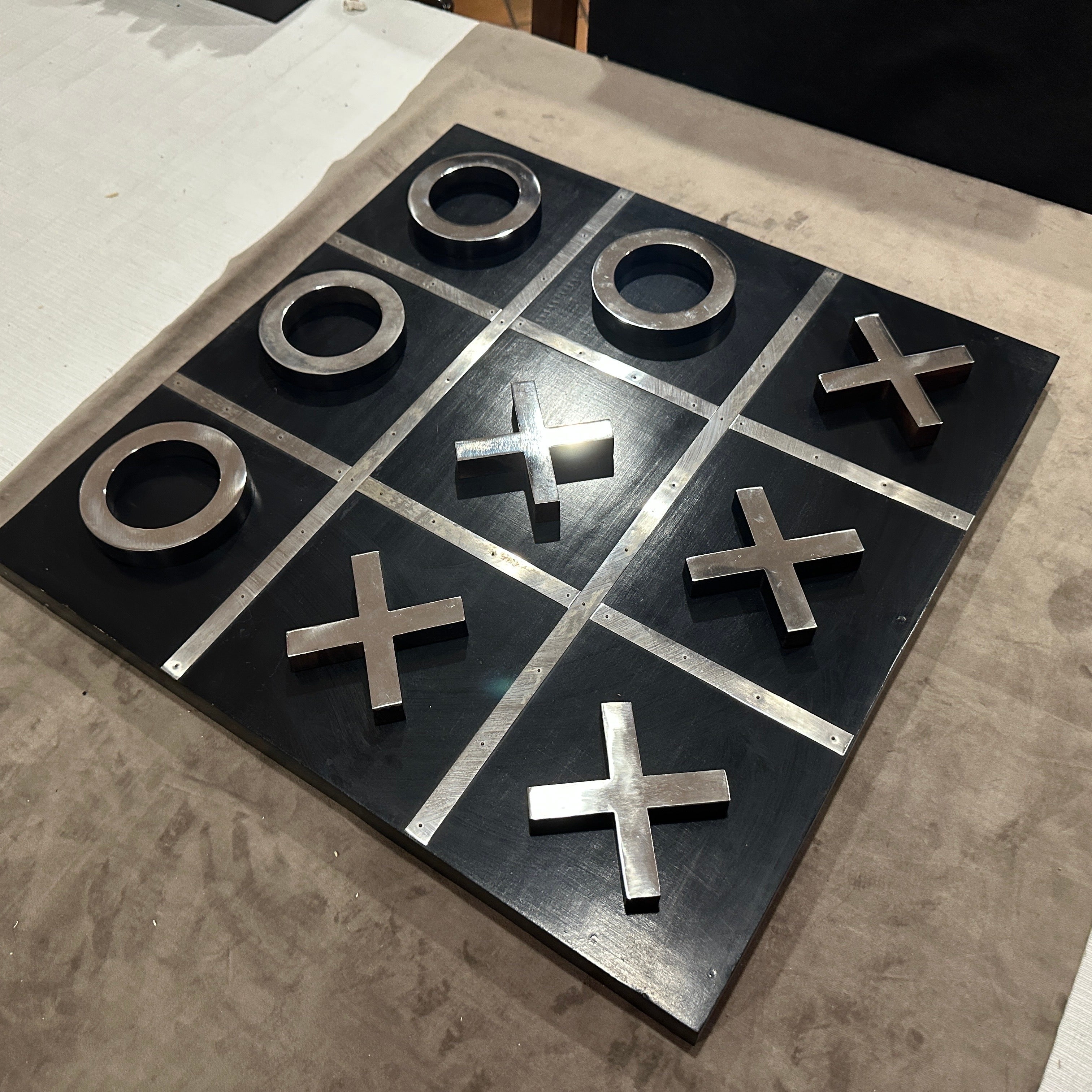 1990s Modern Italian Oversized Tic-Tac-Toe Table Game.
This striking 1990s Modern Italian Tic-Tac-Toe Table Game has been crafted with bold sophistication, this oversized set features a sleek black painted wood board paired with high-contrast