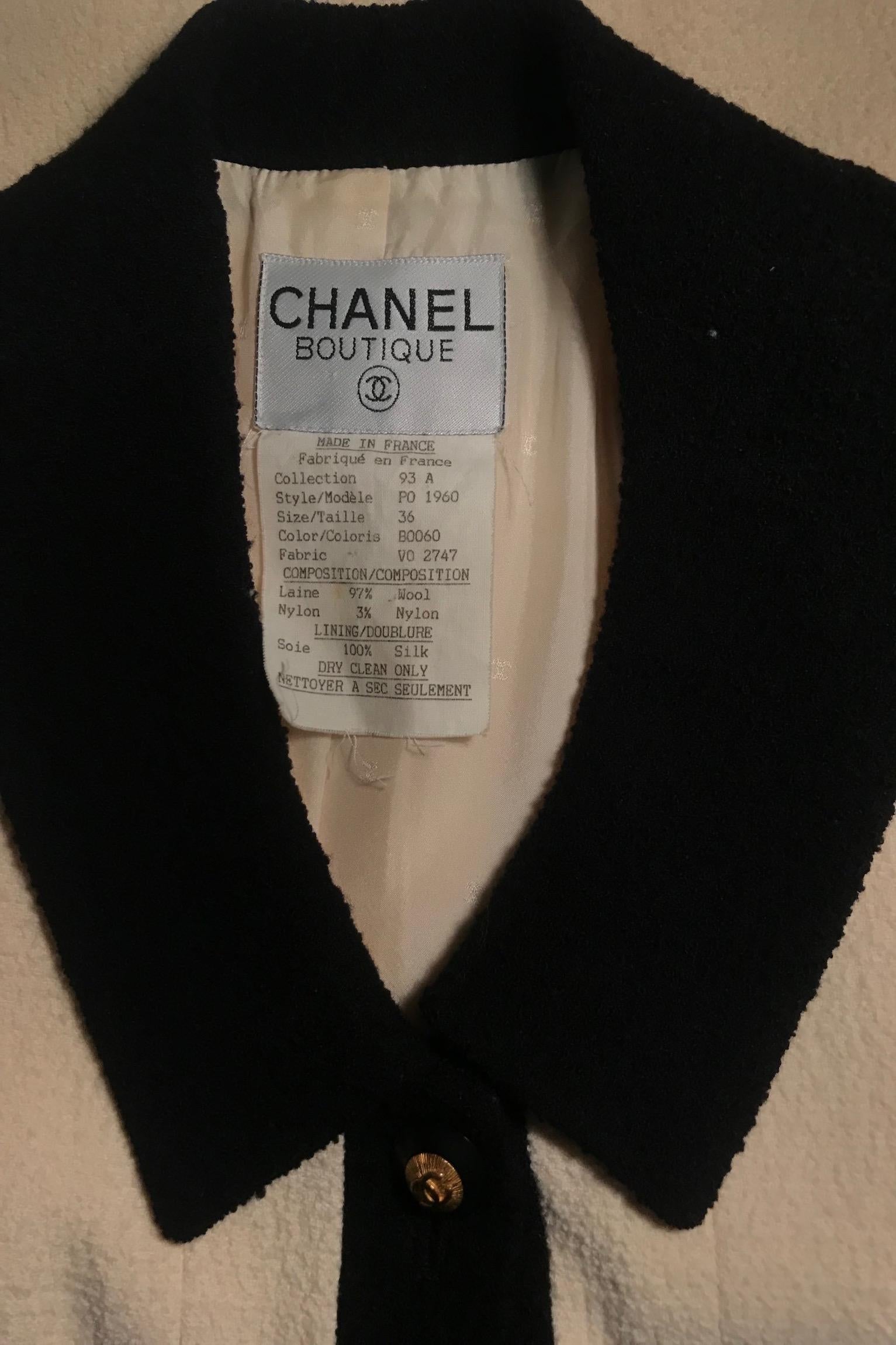 A 1990s Chanel blazer with a black rounded collar, black trim around the cuff, and black piping along the opening of the patch pockets situated at the hip. Gold toned double 'C' logo buttons with black edges are placed along the front and at the