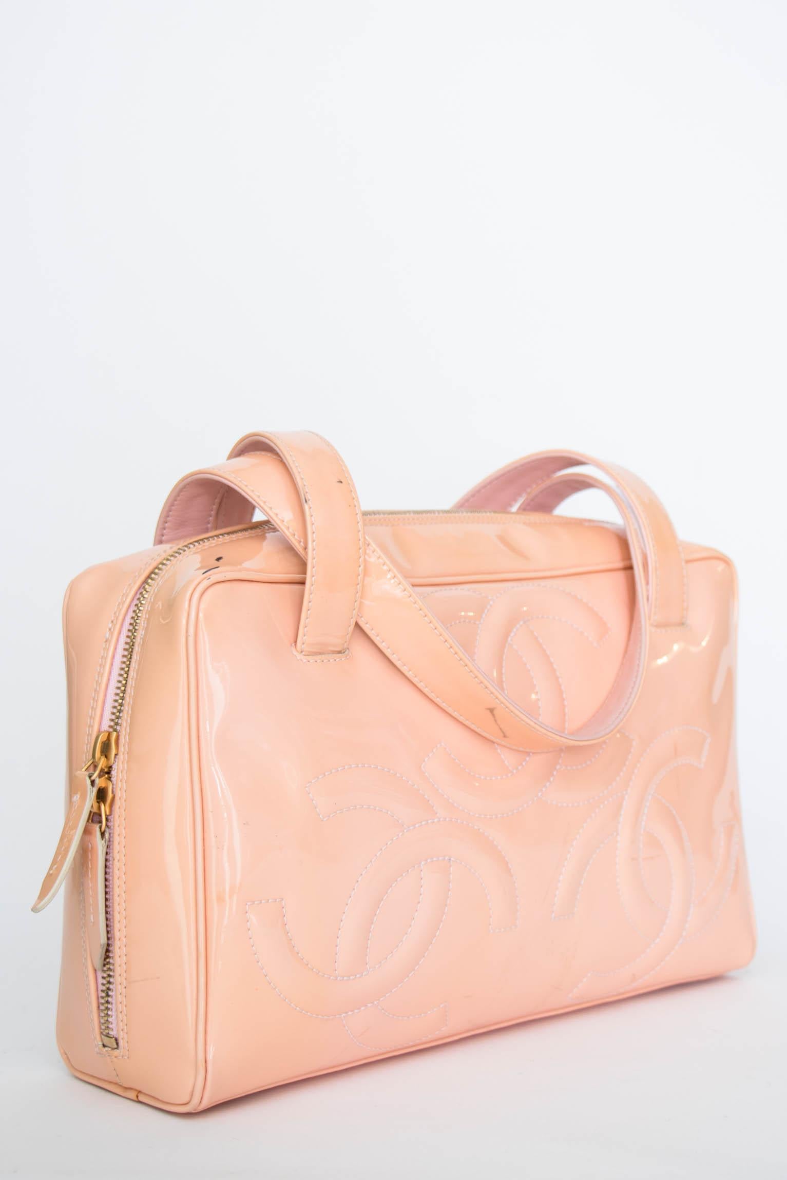 A fabulous 1990s pink Chanel patent leather handbag with a zipper closure, one large compartment and a small inside pocket. The characteristic double 'c' logo is embroidered onto the sides. 