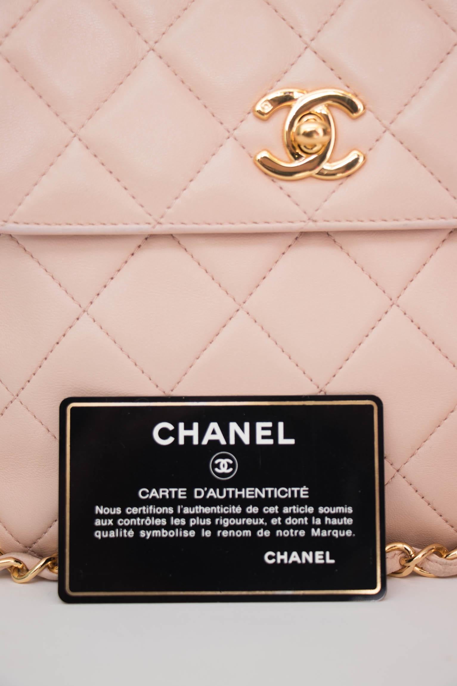 A 1990s pink Chanel lambskin square quilted shoulder bag with gold hardware, a chain strap and a small gold toned double 'c' logo buckle. The bag has one large inner compartment, a small pocket on the outer side and a small pocket on the inside with