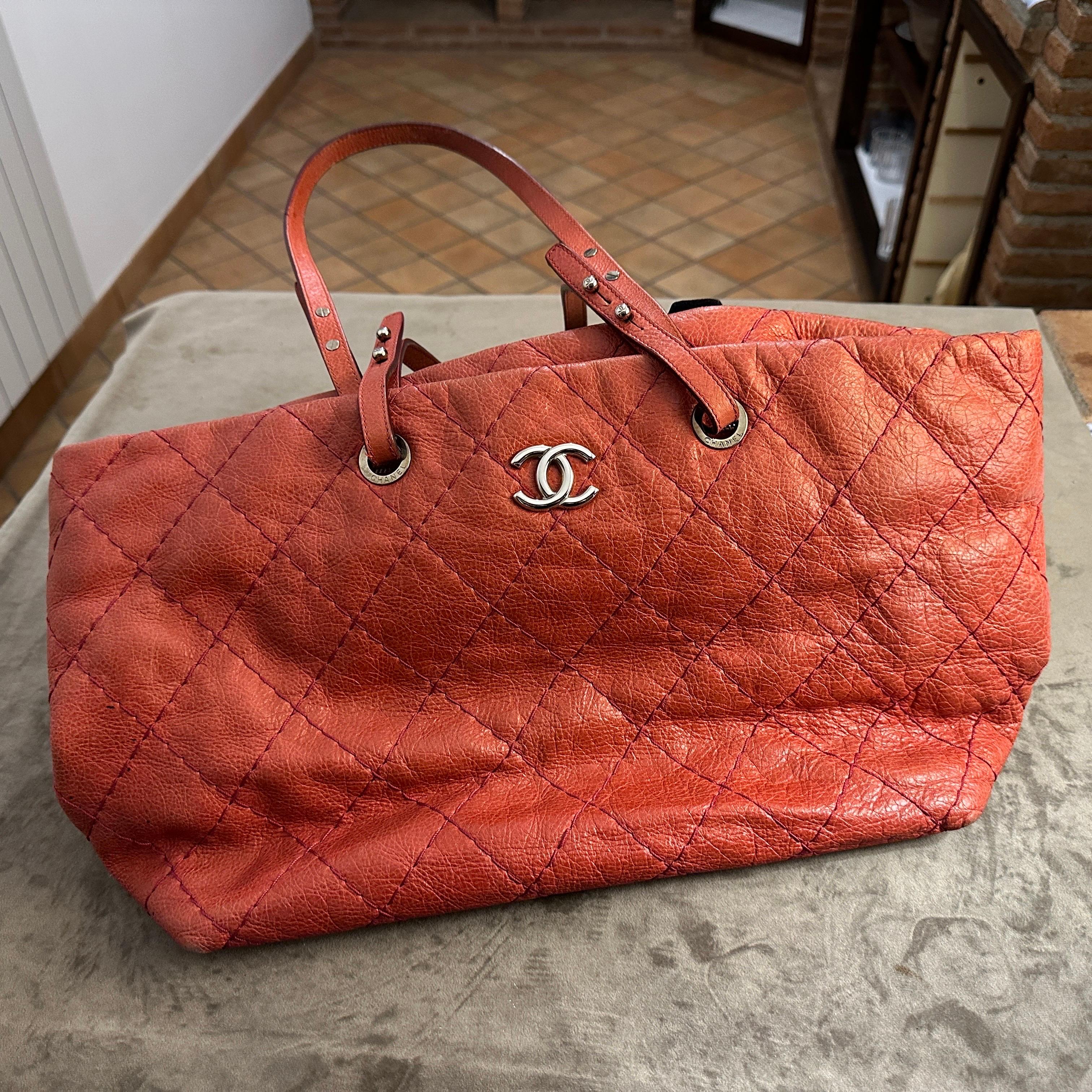 This vintage Chanel tote bag is crafted from pink quilted leather, featuring the brand's signature diamond-stitched pattern. It is accented by the iconic interlocking CC logo in silver-tone hardware, placed prominently on the front. The leather has