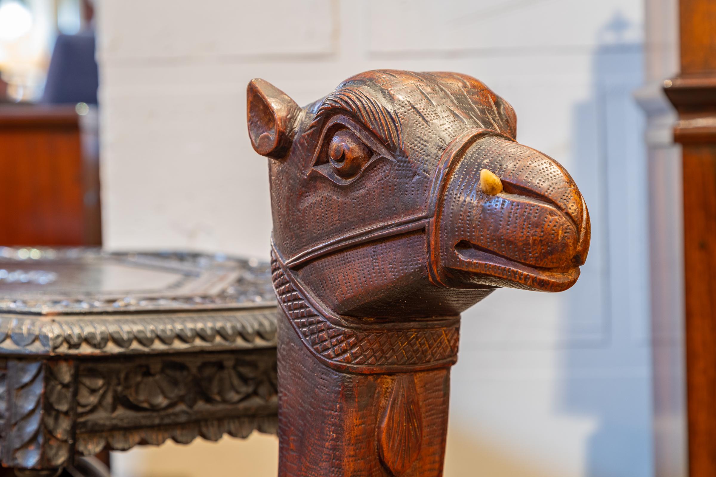 A fine 19th c Anglo Indian carved camel table. Original bone horn in the Camel's nose.