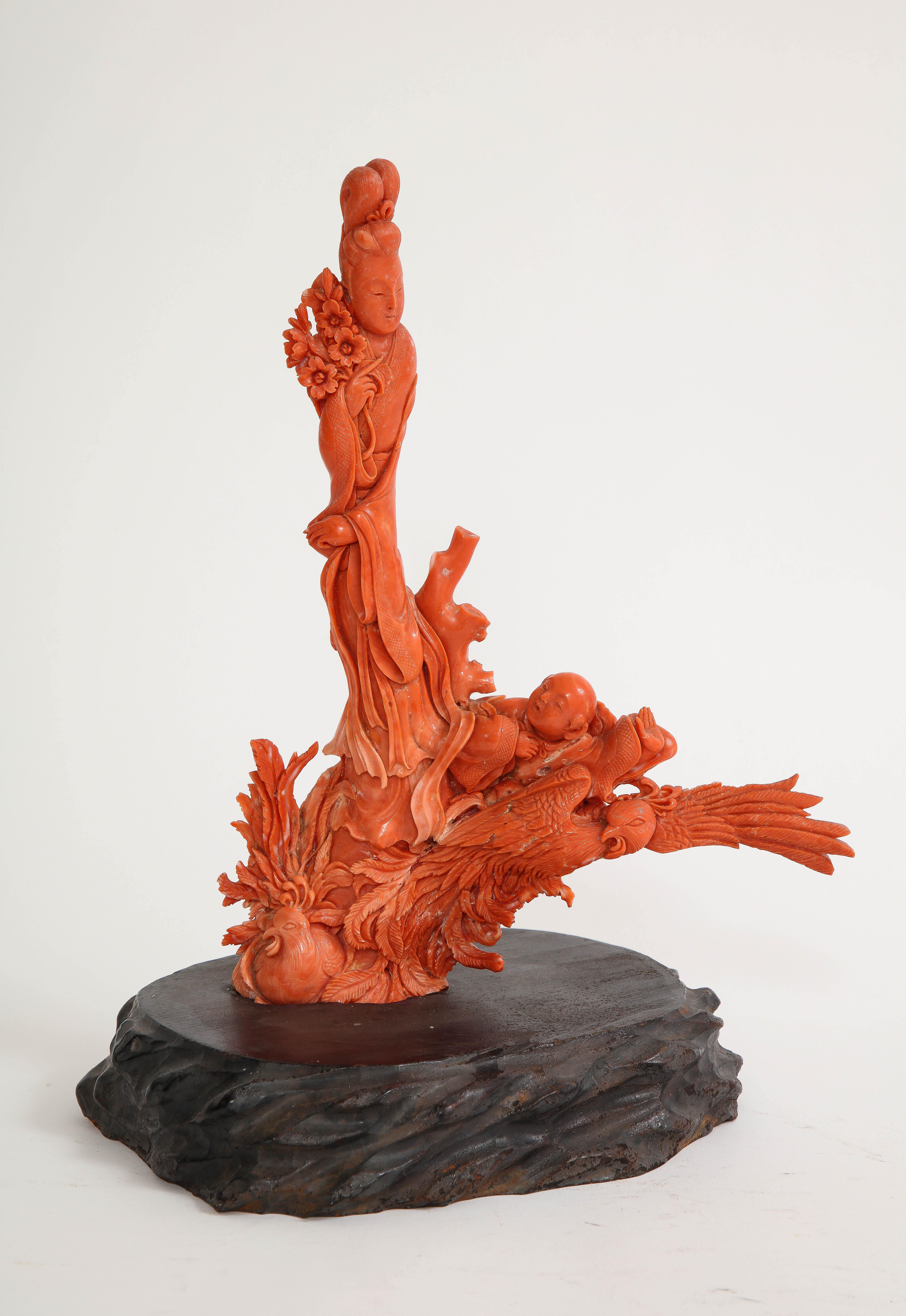 A Wonderful 19th century hand carved Chinese Coral Sculpture of a Maiden and Child on a Phoenix. The tall hand carved coral maiden is seen standing atop two gorgeous phoenix's. On the bottom right hand side of the phoenix is a small baby resting on