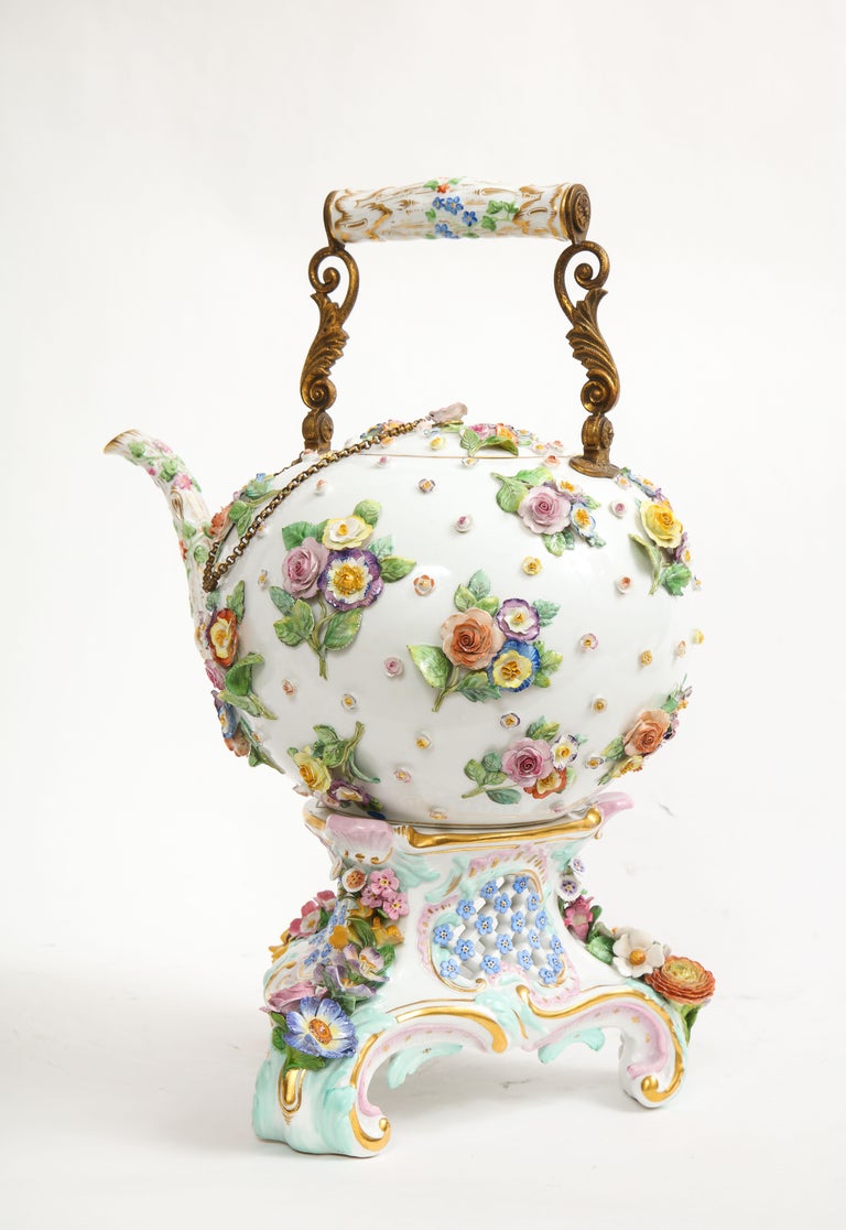 A Fantastic and Large 19th Century Meissen Porcelain Flower Encrusted Tea Pot with Meissen Porcelain Stand and Original Carrying Case.  The body is truly marvelous with a plethora of high relief flowers encrusted throughout.  The spout is