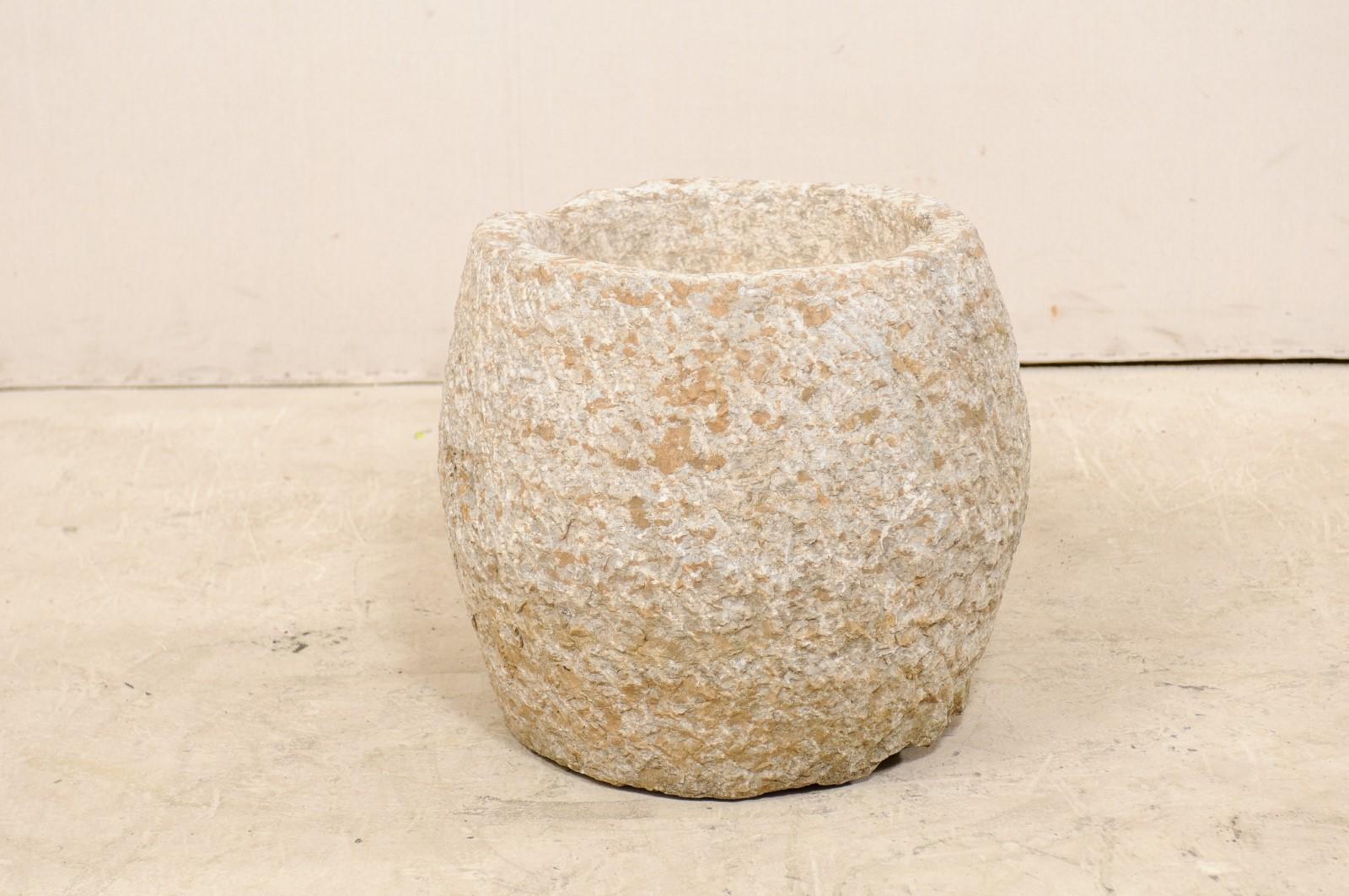 A Spanish large-sized hand carved stone basin from the 19th century. This antique vessel from Spain, with its rounded shape, has been hand carved out of a single piece of limestone, having a nicely textured surface with vertically slanted lines