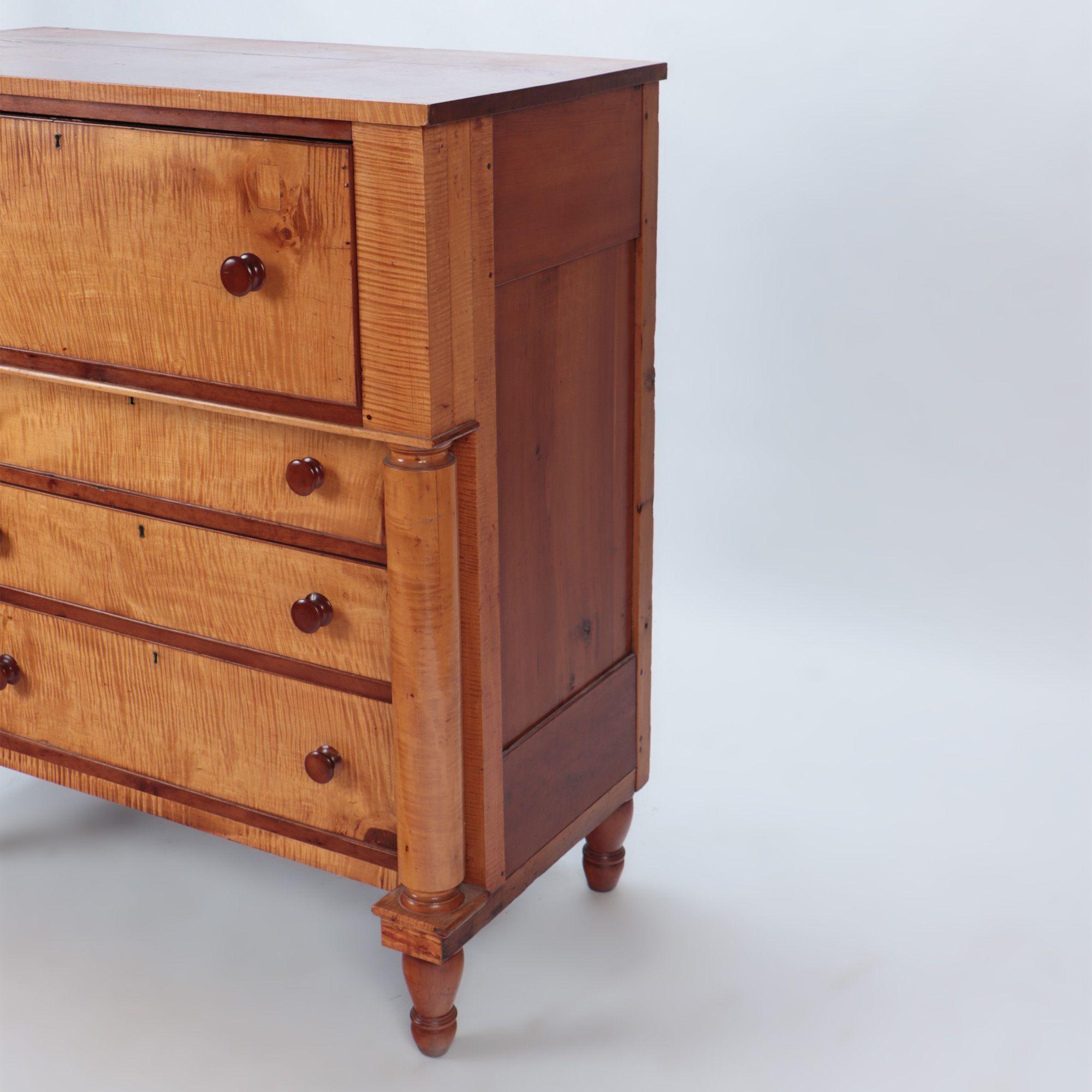 A 19th C tiger maple four drawers dresser. One overhanging drawer supported with full round columns with a set of three graduated drawers below. C 1850.